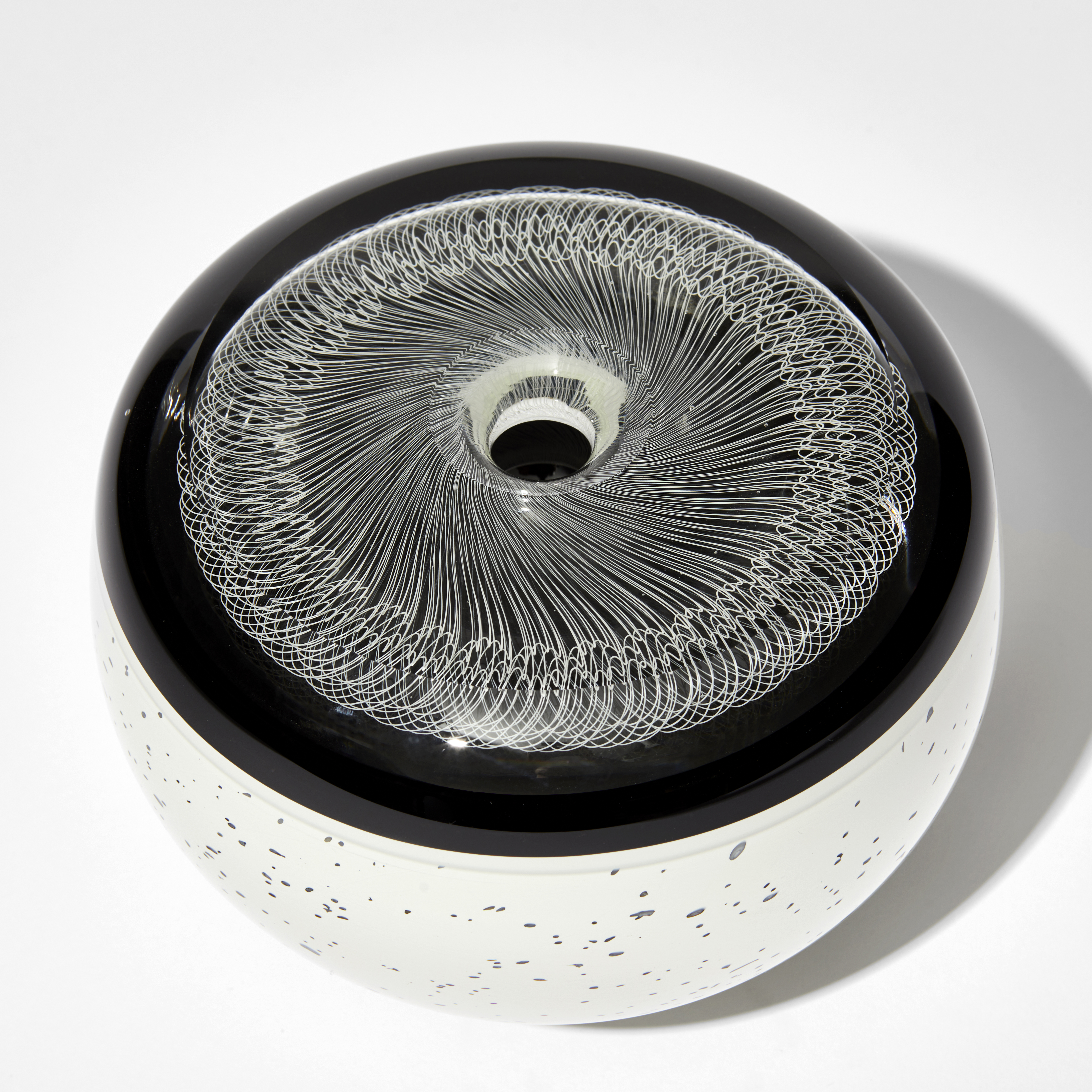 two tone black and white artwork with speckled base and black top with incased filigree lace like design hand made from glass