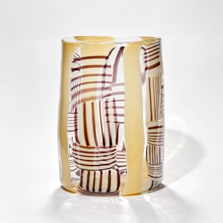 rounded clear glass sculpture with yellow black and red lined pattern