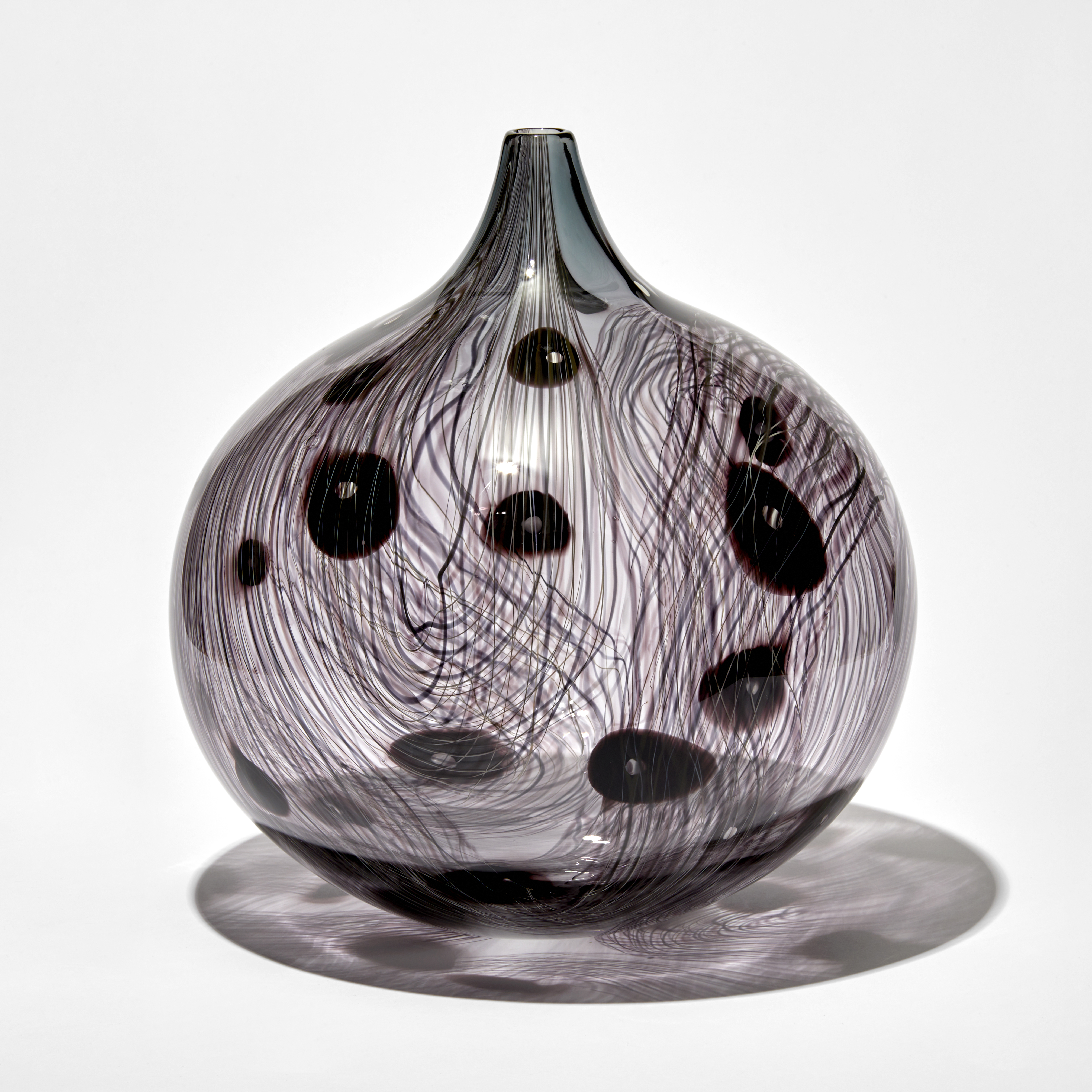 transparent grey and dark aubergine rounded bottle with elongated neck with fine organic cane pattern and dots hand made from glass