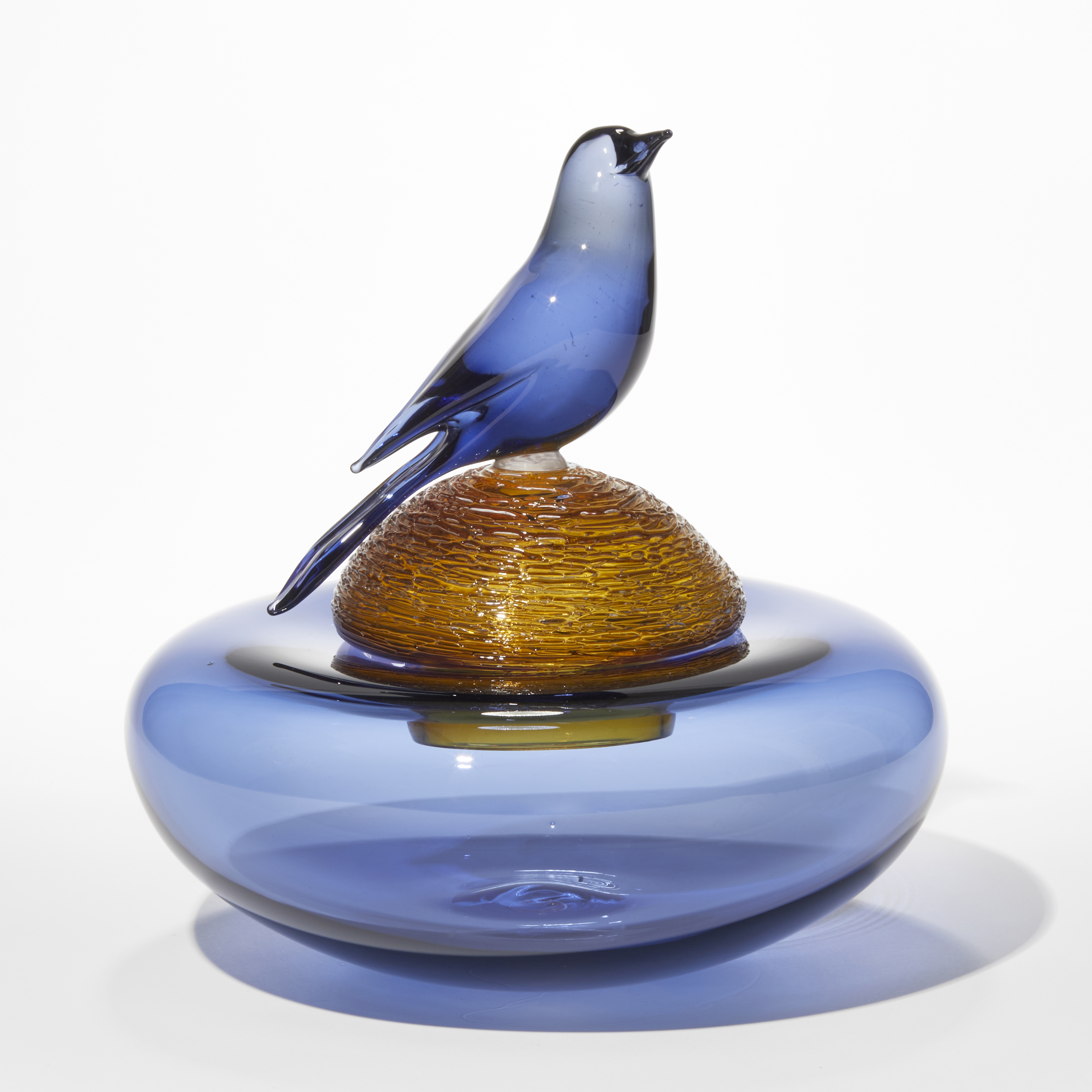 squat low and round rich royal blue bowl with amber domed lid with birds nest texture and perched royal blue bird hand blown and sculpted from glass