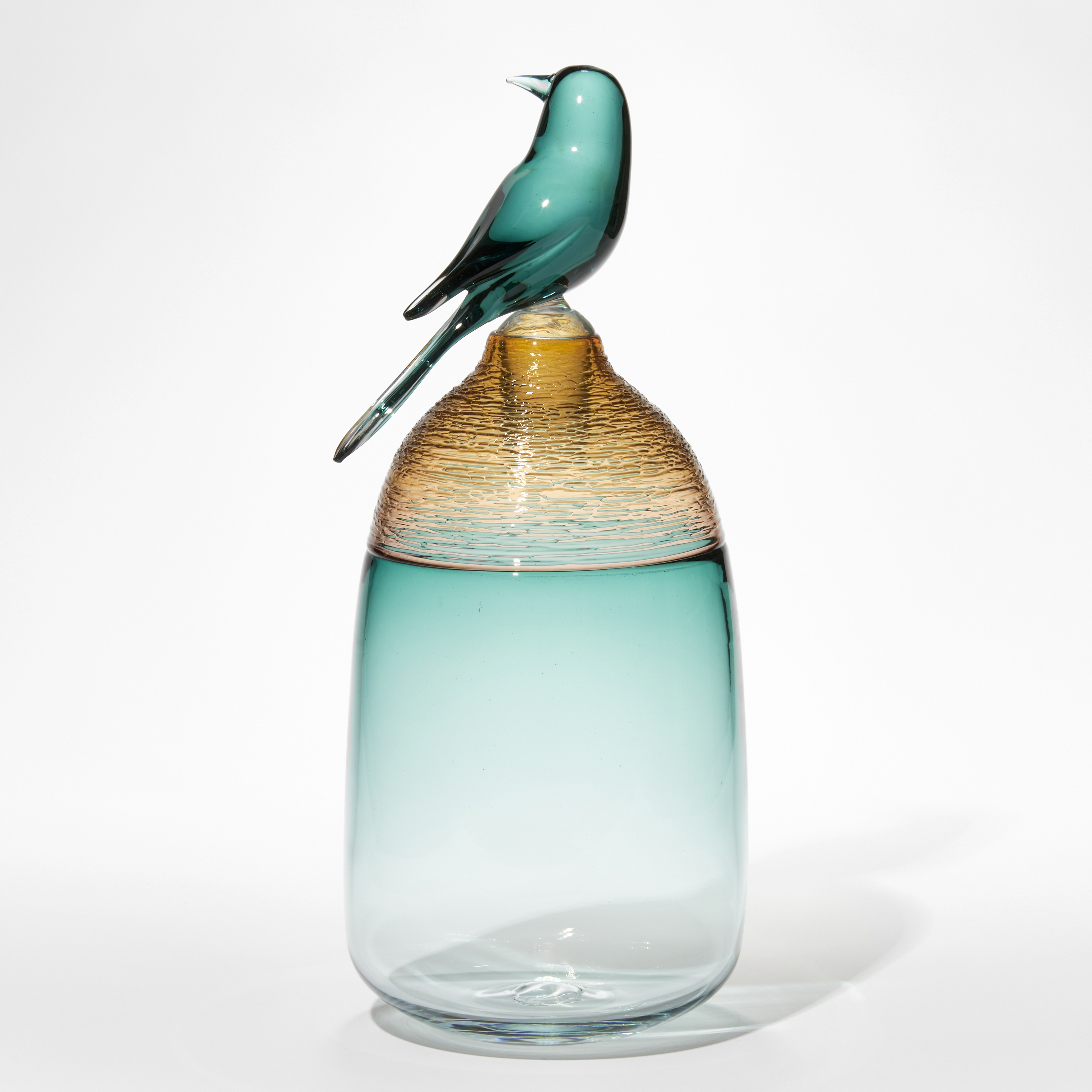 transparent fading jade green jar with amber textured top third section and stopper with a jade green sculpted bird attached hand made from glass
