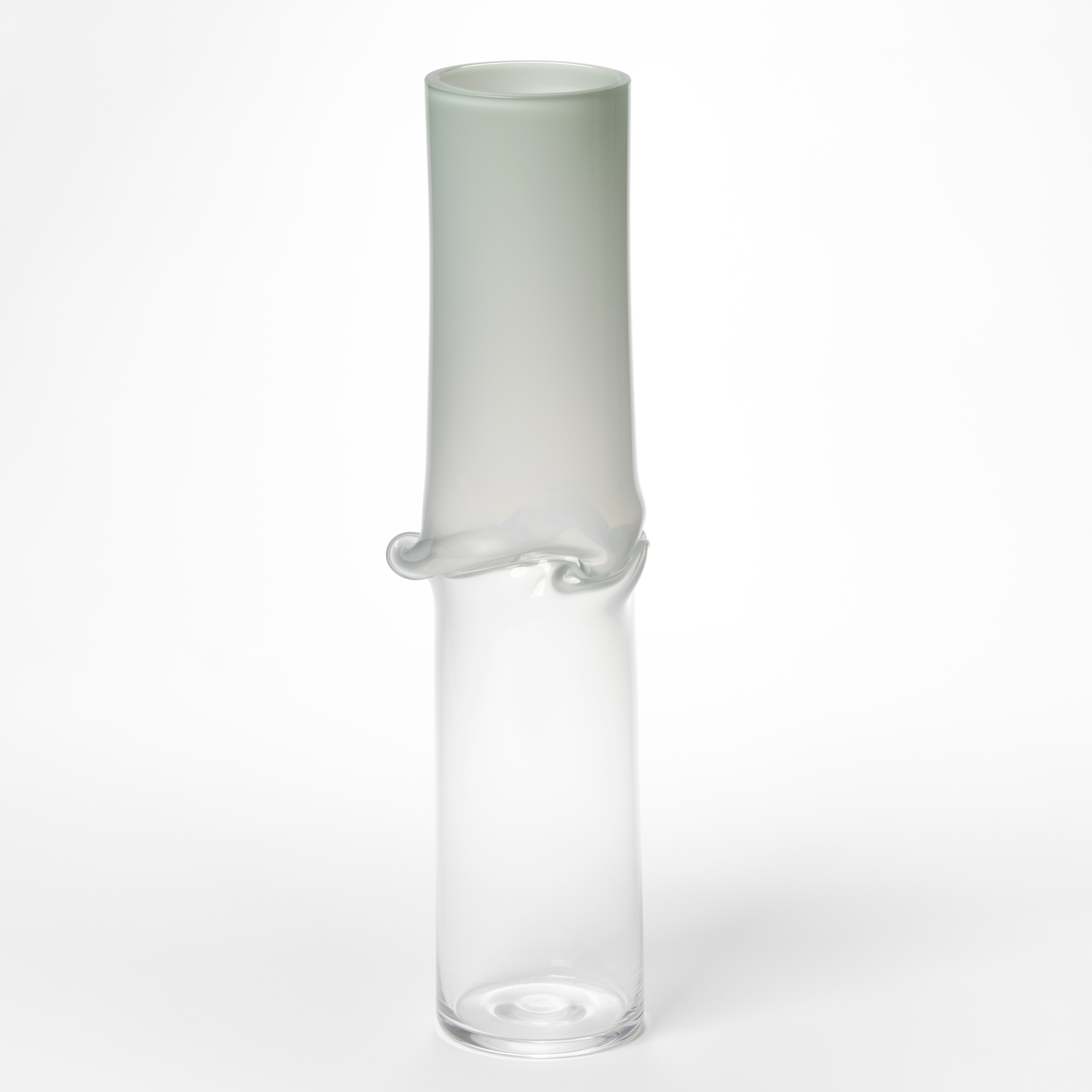 tall cylinder with transparent clear bottom half and opaque celadon green top half with central creased and slumped rippling and bulging waist hand made from glass