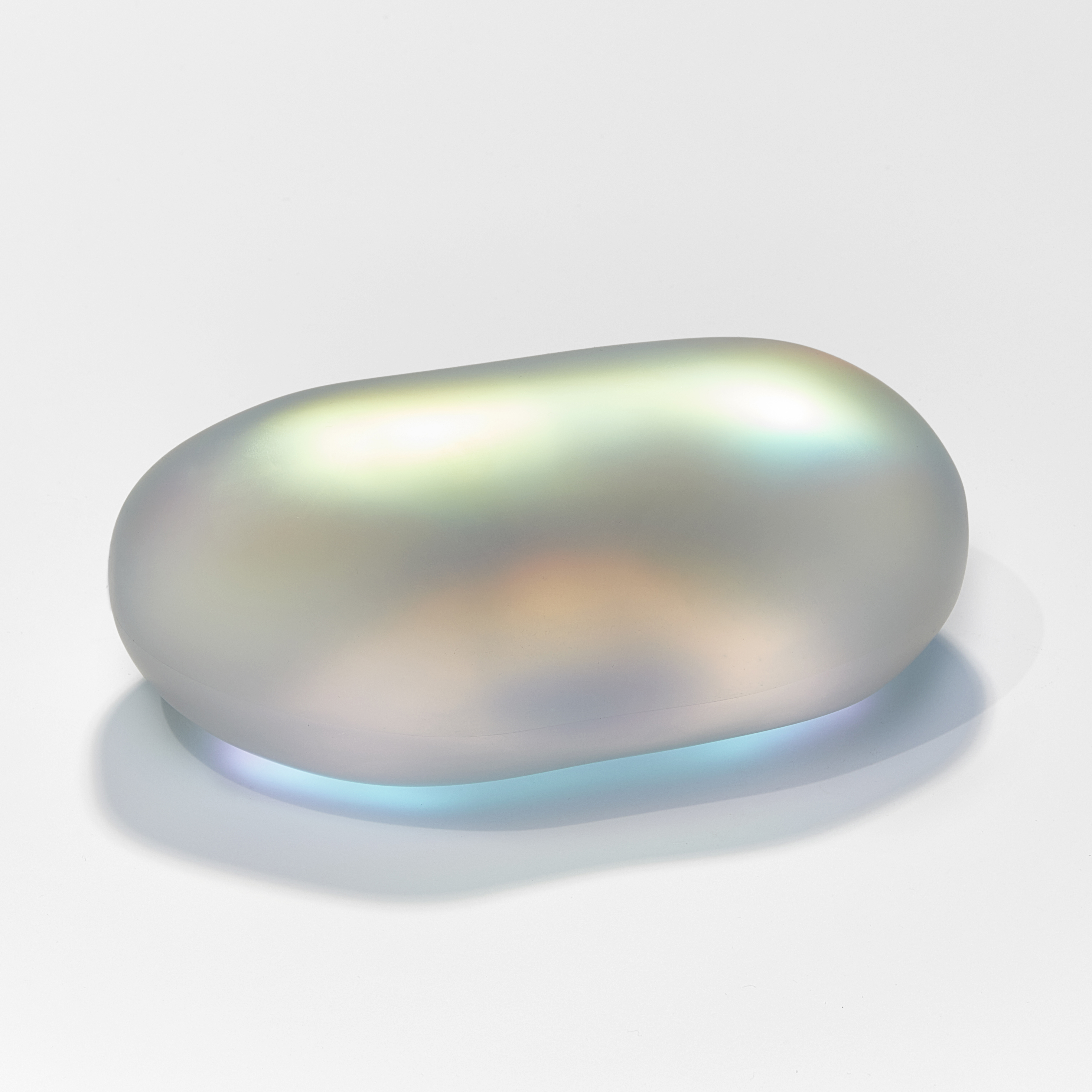 shimmering glass amorphic pebble rock sculpture with inner myriad of colours with the appearance as if emitting light from within hand made from blown and sculpted glass