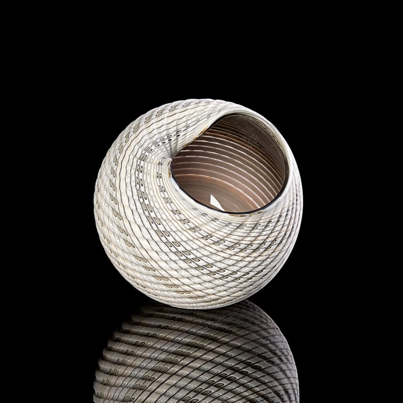 round shell like vessel with light coloured matt exterior with cut surface in white grey and blue and shiny interior in brown bronze hand made from glass