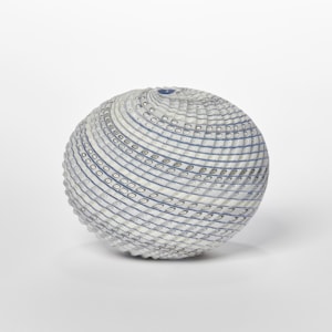 off white cream blue and soft green ovoid shaped vessel with spiralling lines in colour around the form and cut sections within the surface hand made from glass