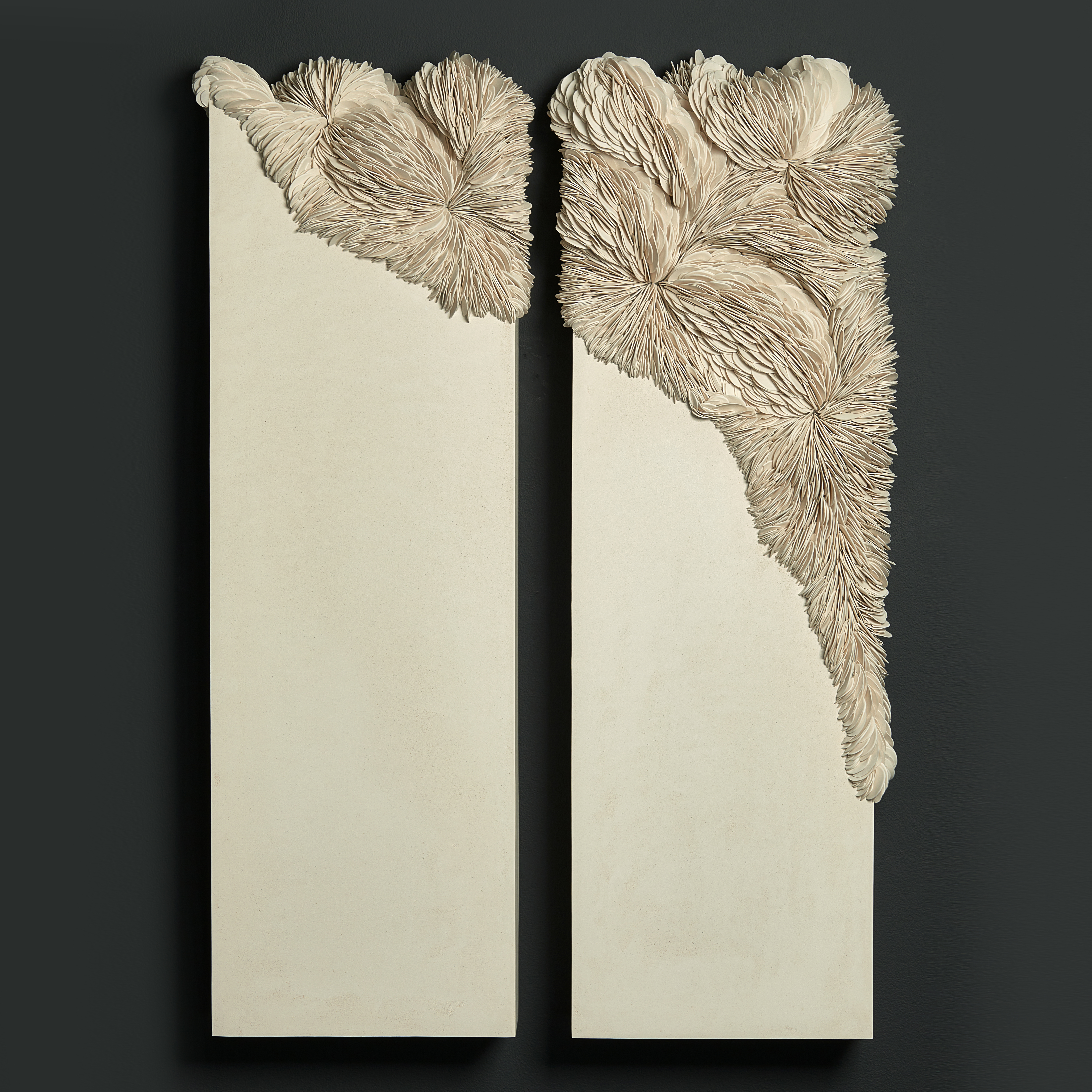ivory off white cream twinned wall mounted rectangular artworks with traversing textured section with embedded shards traversing from one panel to the other in an organic spread hand made from porcelain and tadelakt plaster