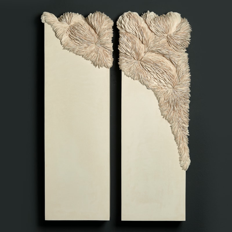 ivory off white cream twinned wall mounted rectangular artworks with traversing textured section with embedded shards traversing from one panel to the other in an organic spread hand made from porcelain and tadelakt plaster