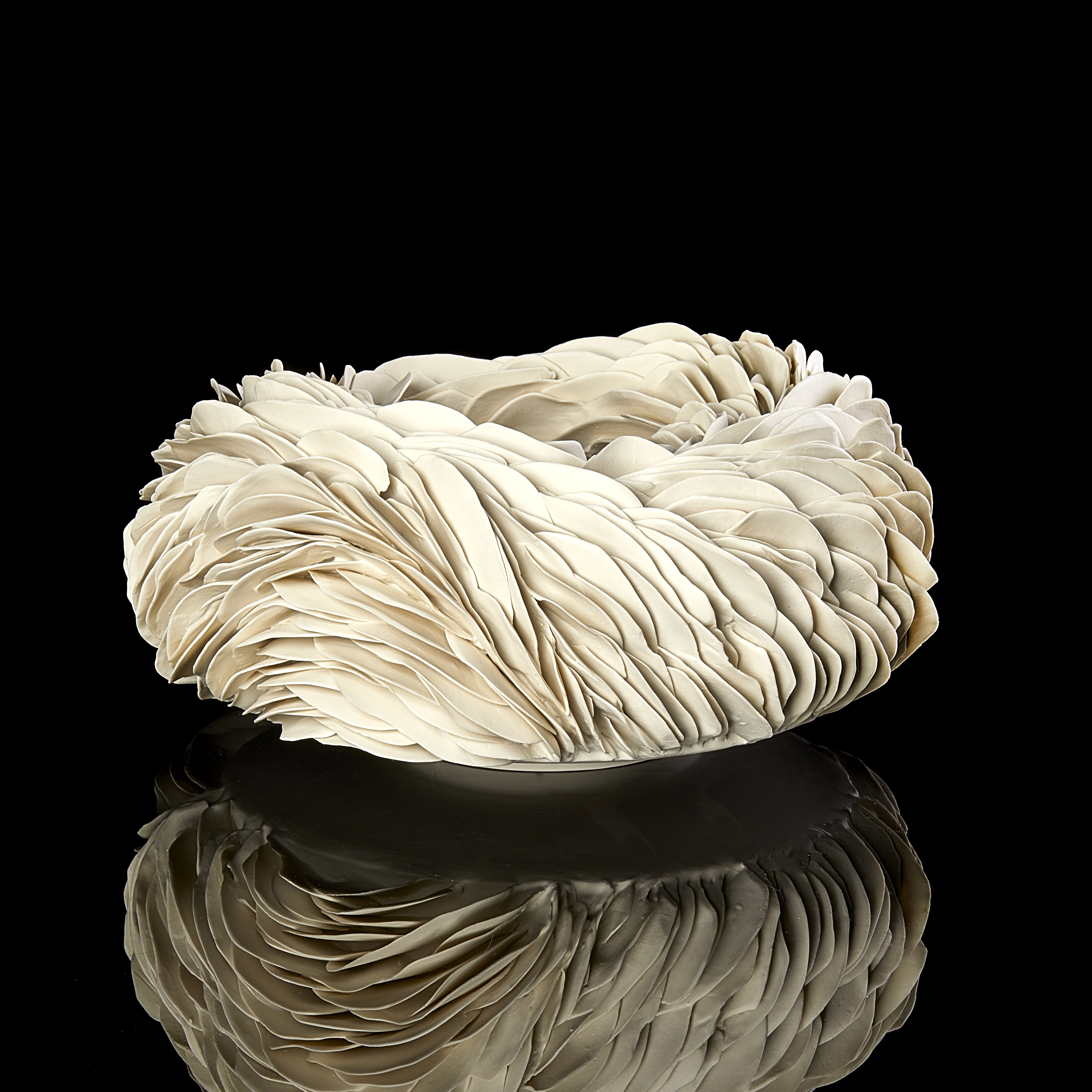 round off white creamy bowl covered in shards with a weather worn appearance and almost like irregular animal scales hand made from porcelain