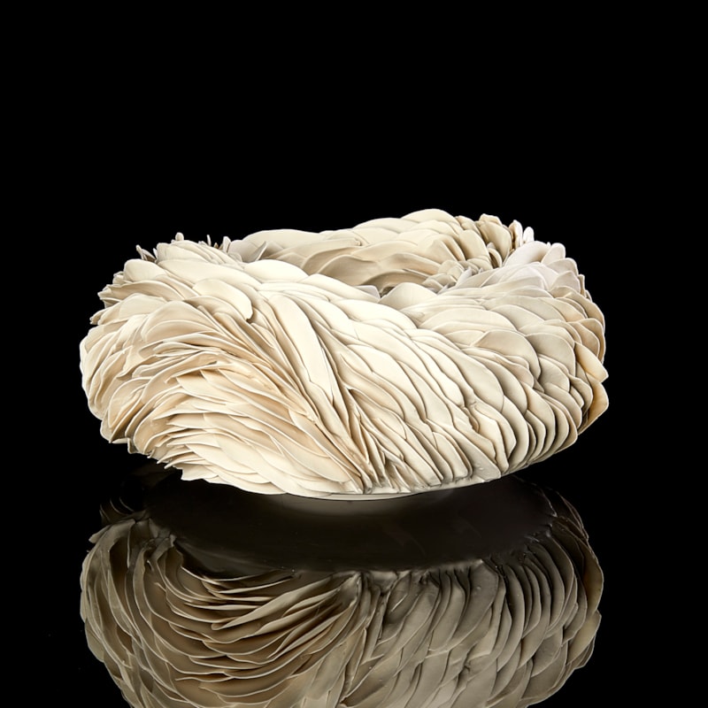 round off white creamy bowl covered in shards with a weather worn appearance and almost like irregular animal scales hand made from porcelain