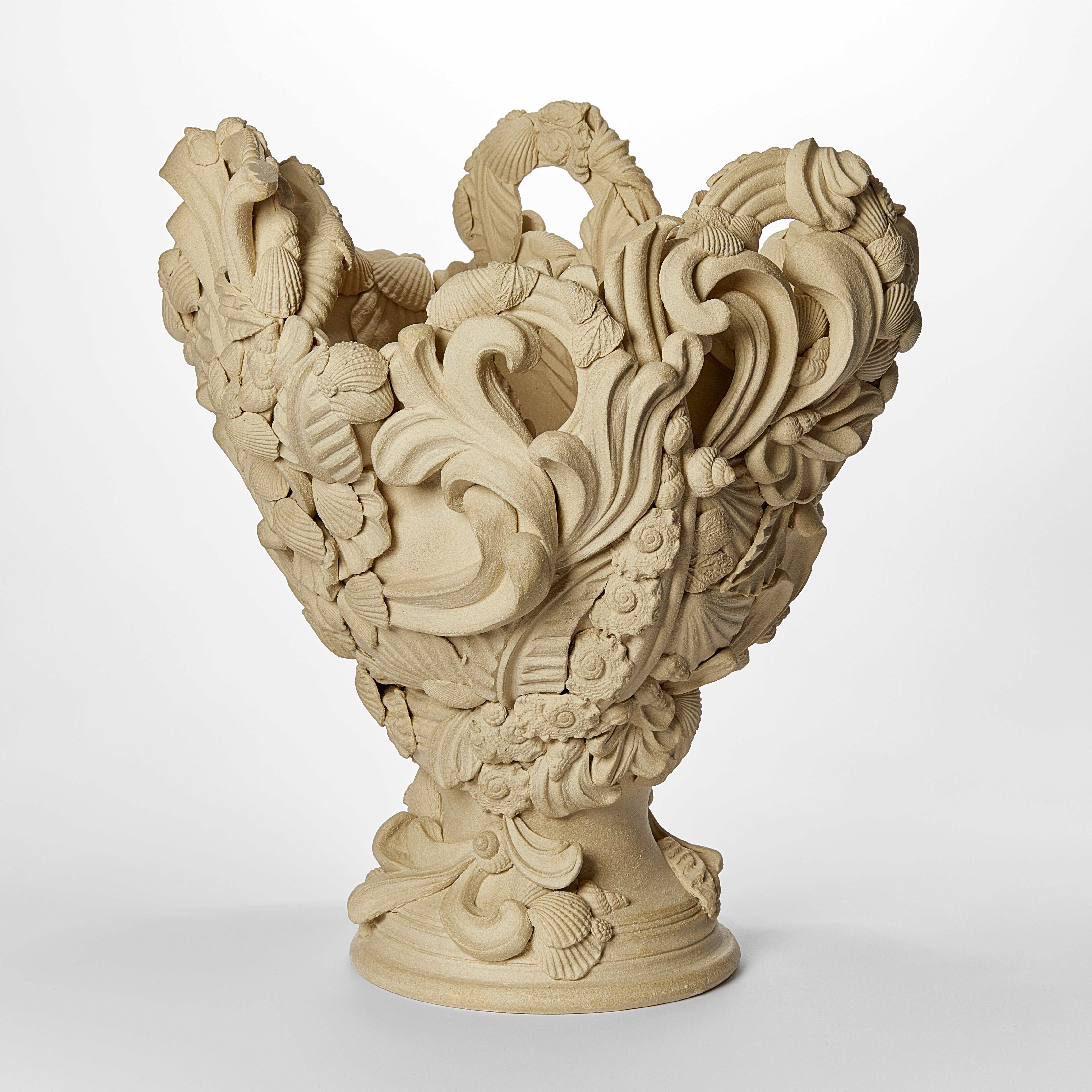flared light biscuit coloured vase with dramatic architectural swirls flourishes shells and floral details with undulated top edge hand made from white saint thomas clay