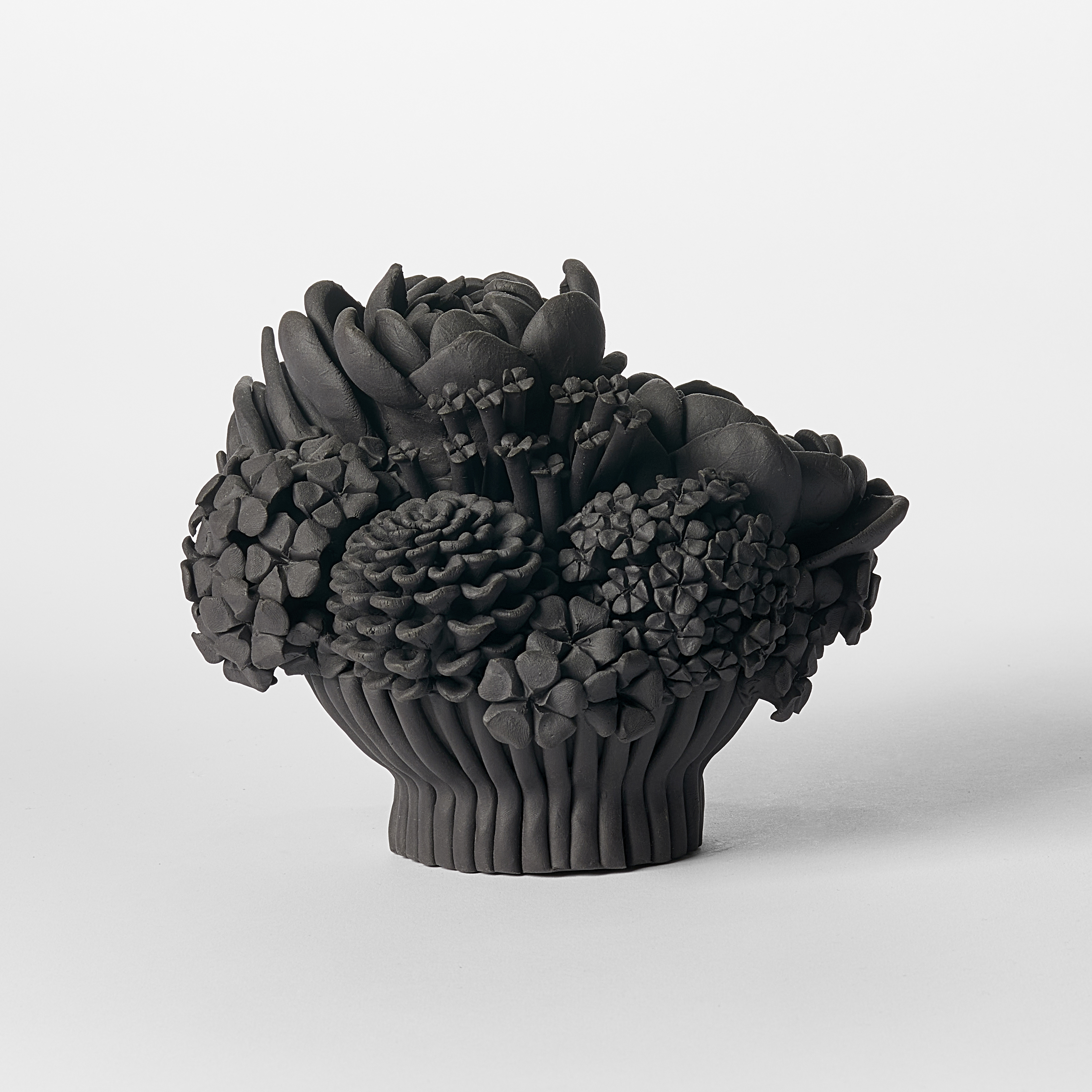 black stoneware sculpted artwork of mixed flowers