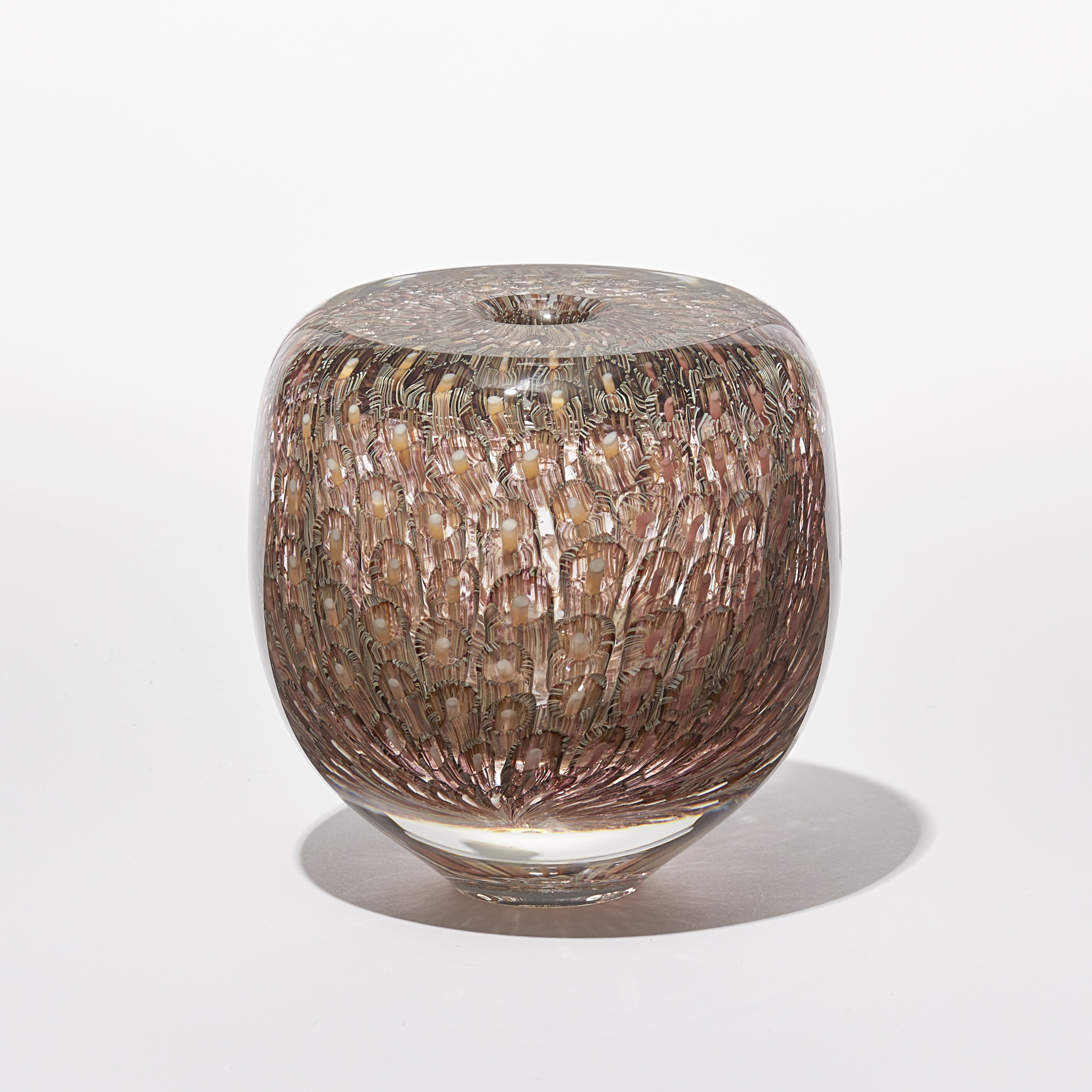 salmon aubergine and soft yellow finely patterned low round vessel with tiny aperture opening in the middle of a flat top hand made from glass