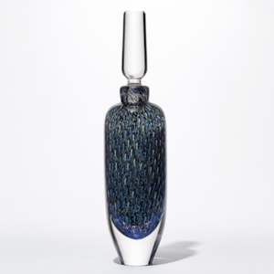 tall rounded transparent bottle with long elegant clear stopper with the main body covered in an fine intense organic repeat pattern in blue indigo turquoise jade and aquamarine hand made from glass