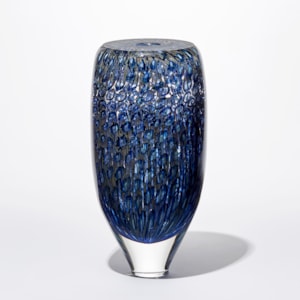 transparent rounded tall tapering at the base vessel with flat top and small central opening covered in a fine detailed intense pattern in blue indigo turquoise and aquamarine handmade from glass