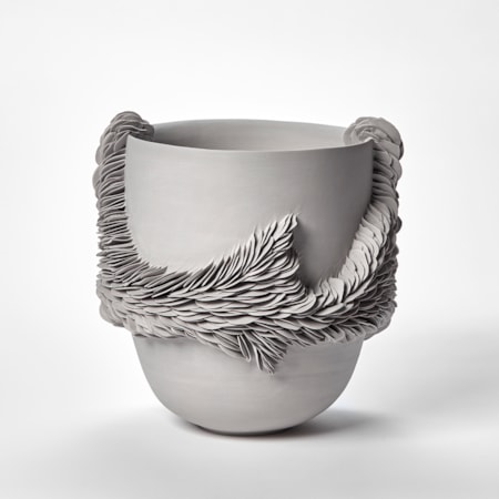 tall high sided round grey bowl with an organic trail of embedded organic shards traversing around the form and over the top rim on two sides hand made from coloured porcelain