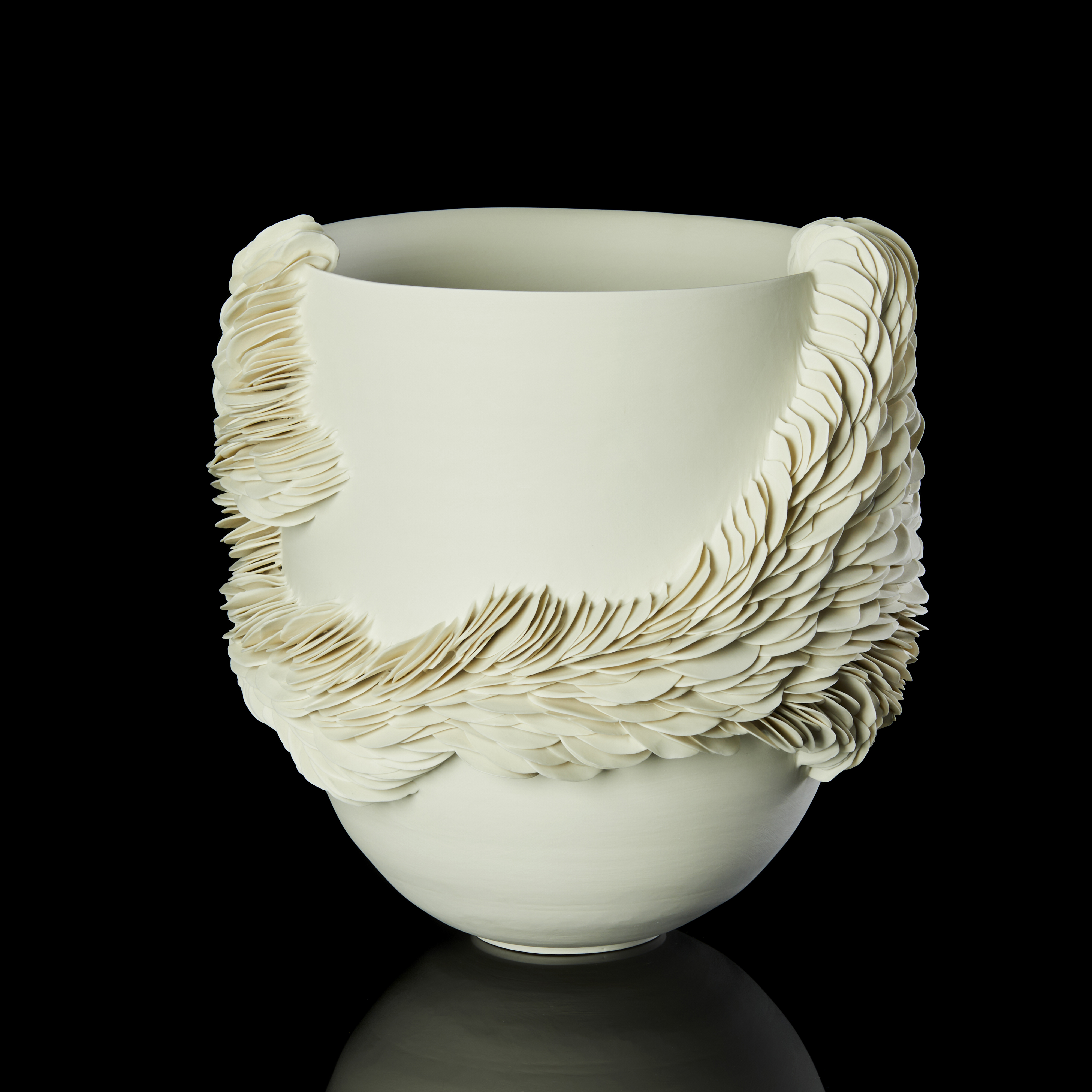 round high sided off white alabaster coloured bowl with exterior organic repeated decorative texture made up of hundreds of scale like shards encircling the main form and reaching the rim in two places hand made from thrown and sculpted porcelain 