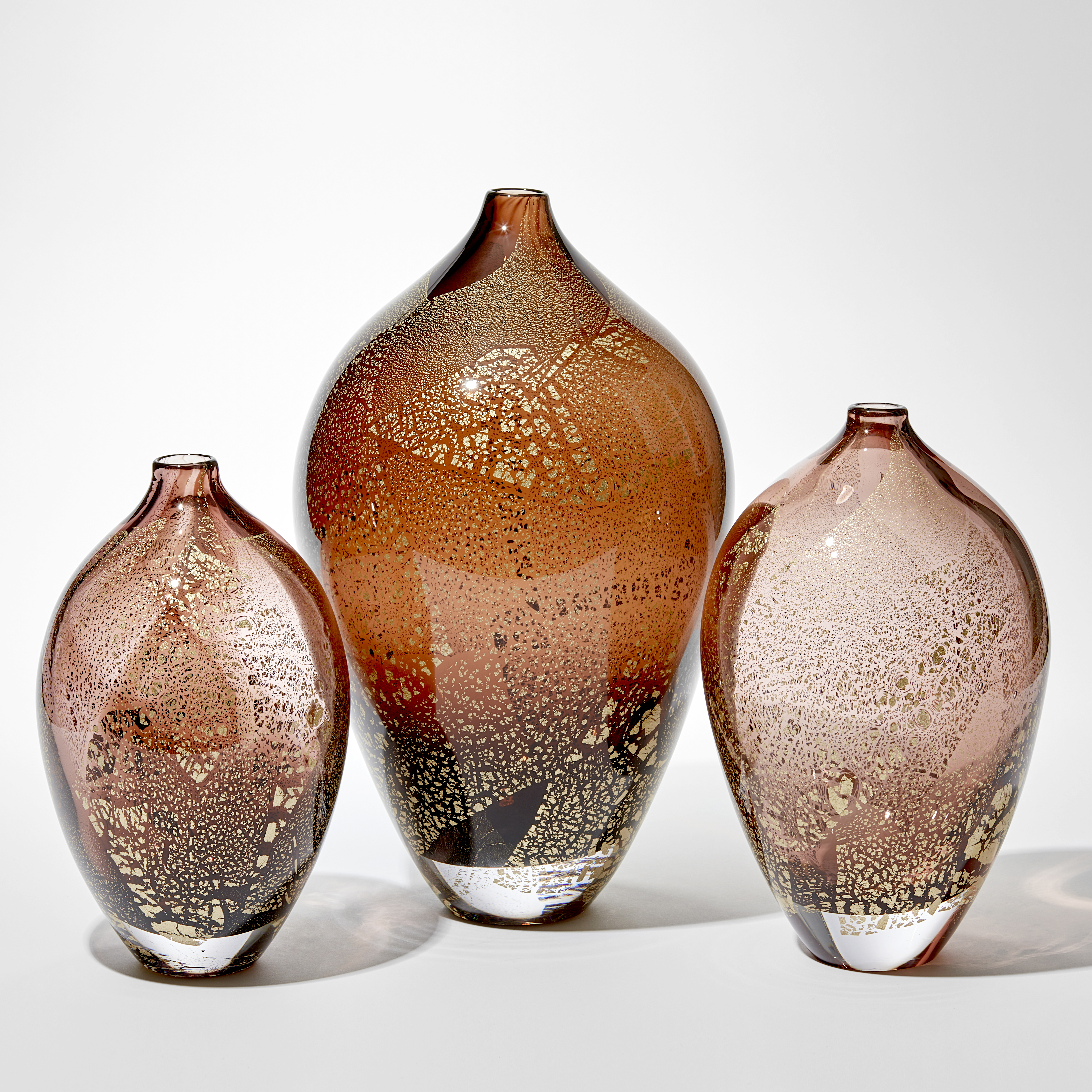 art glass sculptural vases in amber and aubergine with gold leaf-shaped speckles on exterior
