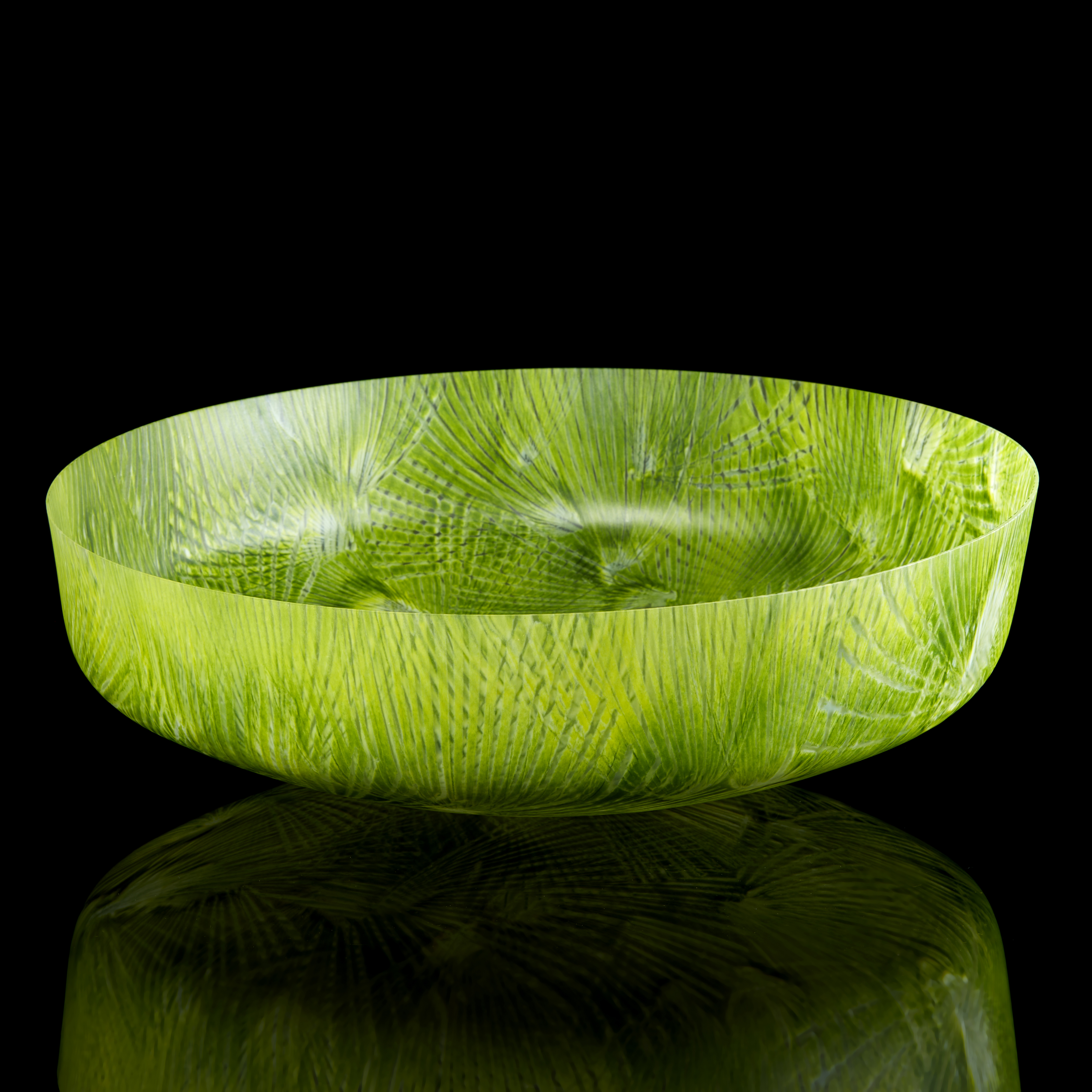 vibrant lime and mixed green low round centrepiece bowl with rounded base and short straight sides covered in angular abstract palm tree slight relief repeat patterns hand made from glass