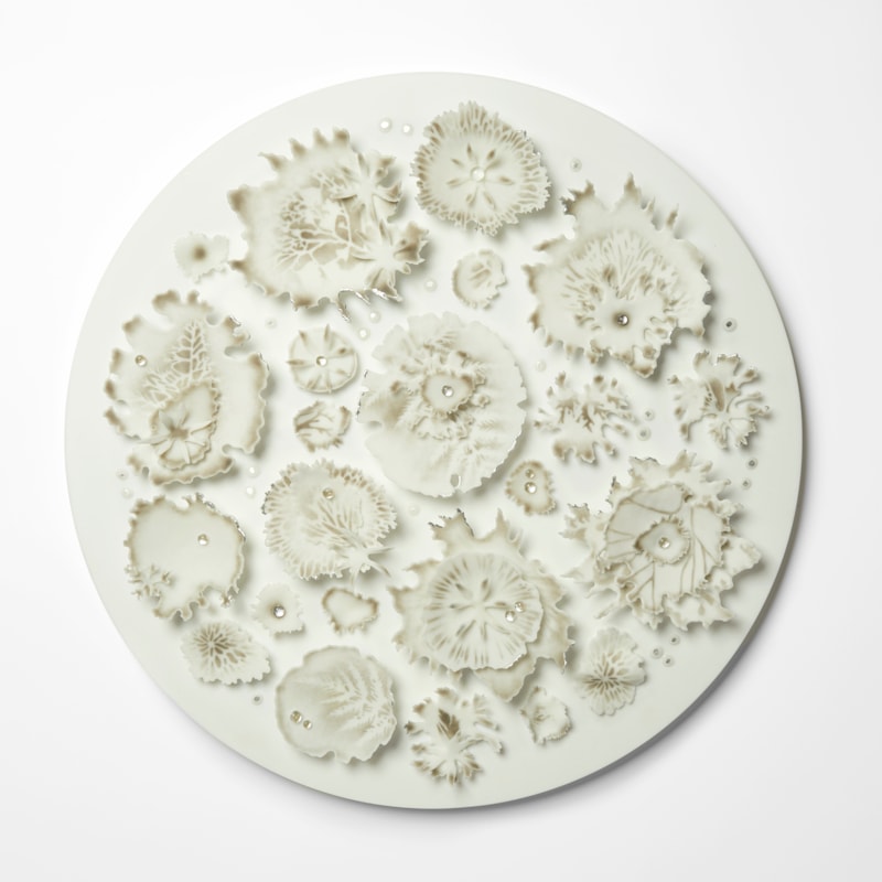 opaque white round wall hung artwork with front face covered in organic growths and mushroom gill inspired details with soft bronze brown speckled colour drops of clear glass water like droplets and silver highlights handmade from glass