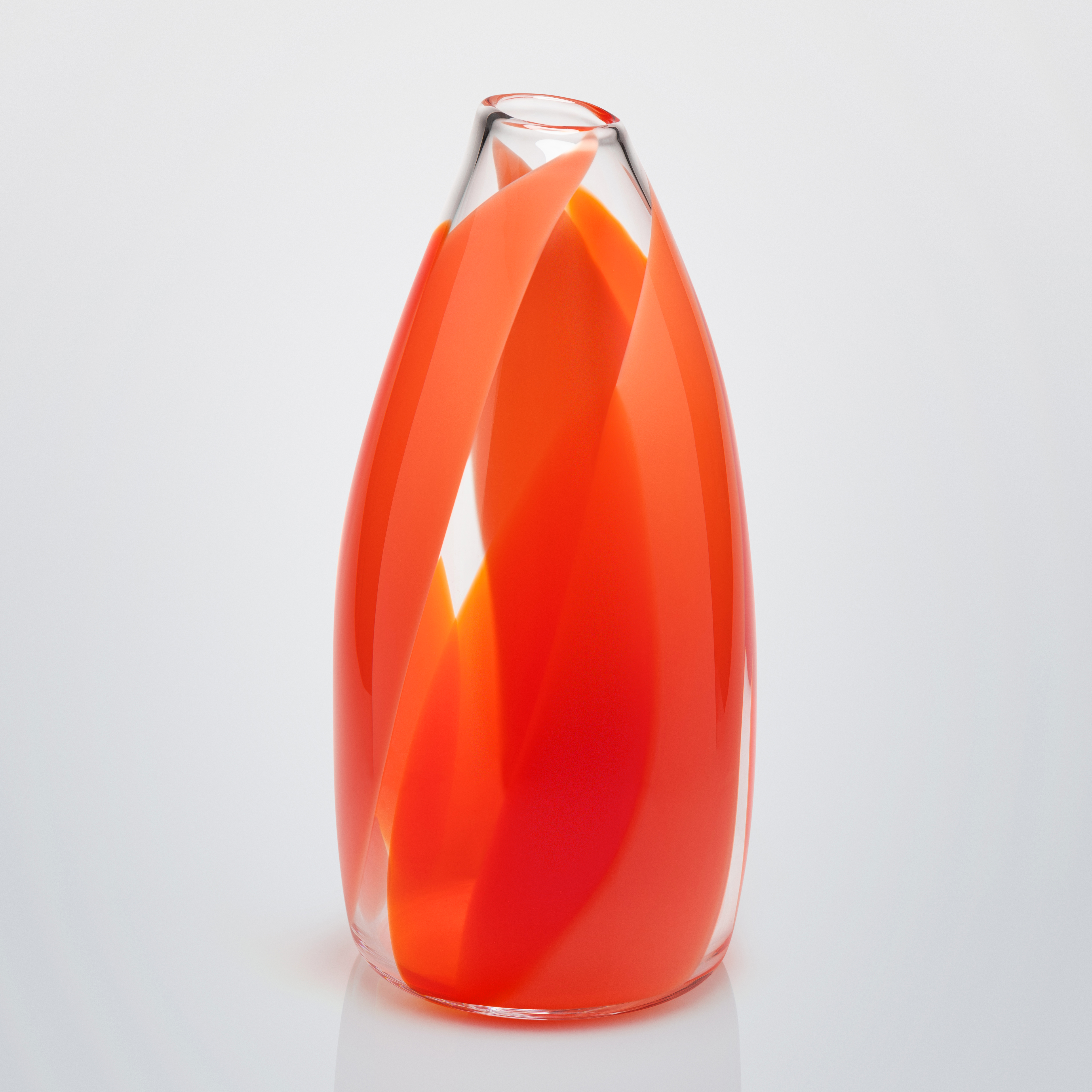 tall round pointed top with small opening clear vase with wide soft bands of colour in orange red and coral curling round the form from the base to the top hand made and blown from glass