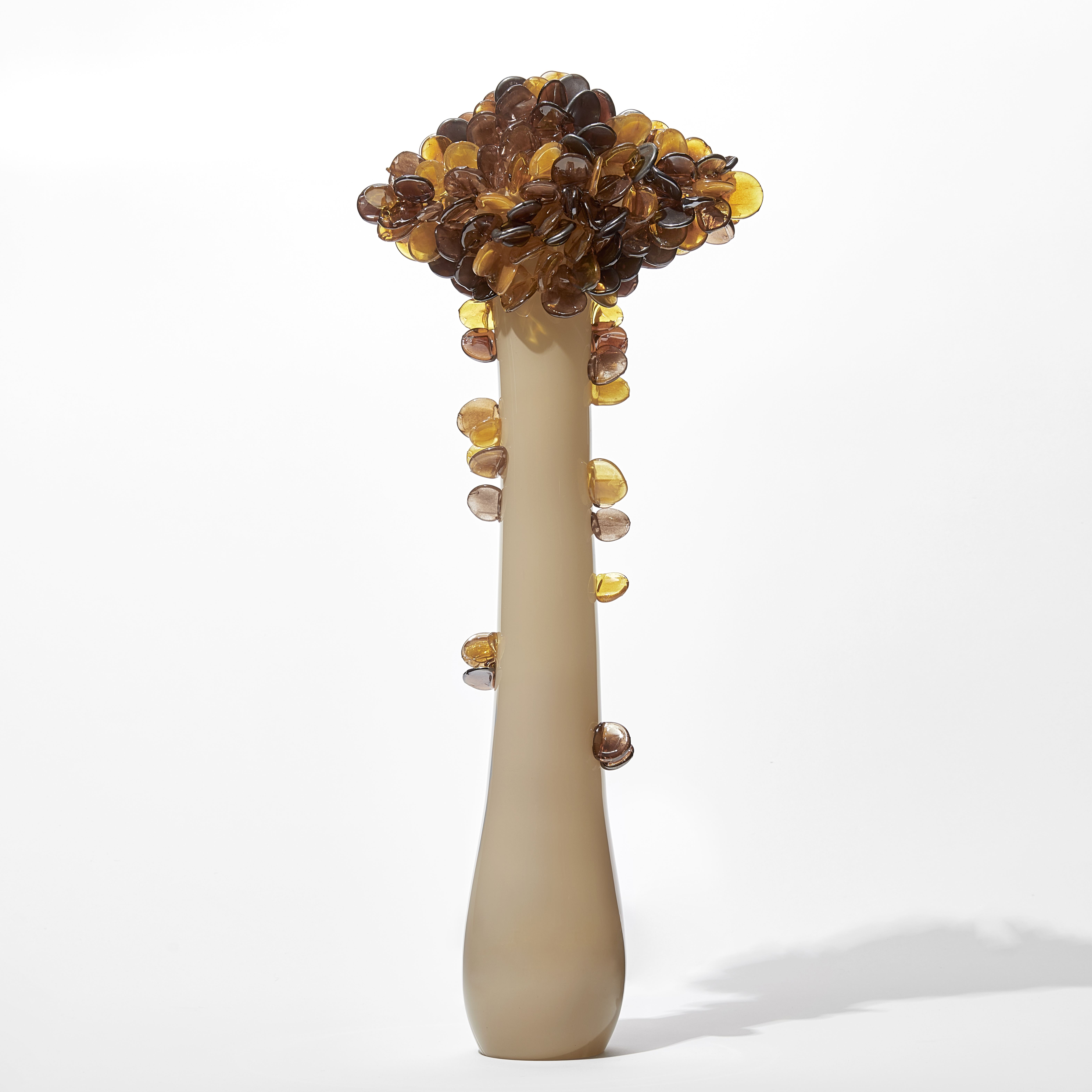 tall abstract tree sculpture with long opaque bronze trunk with diamond shaped canopy covered in lollipop shaped leaves in amber and brown handmade from glass