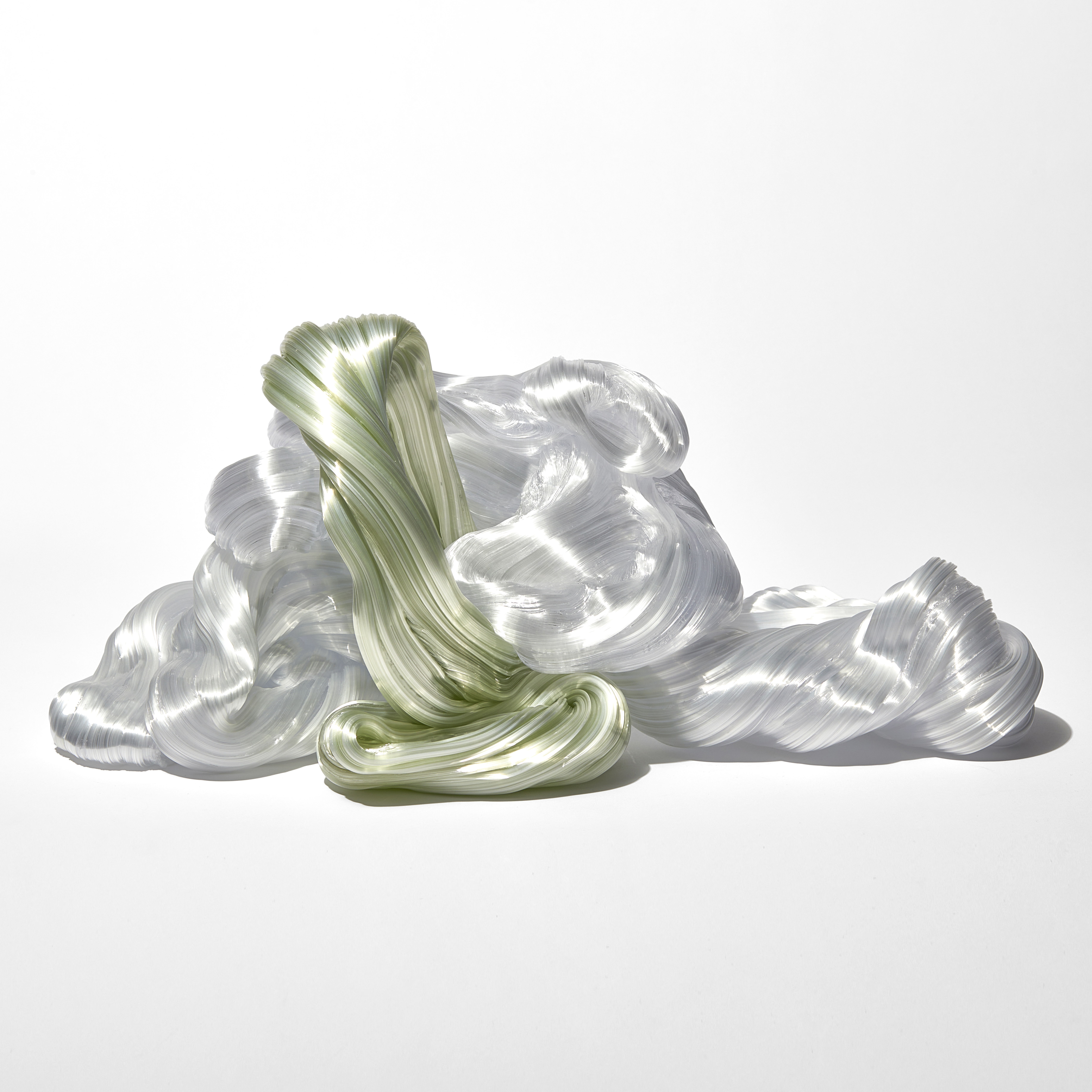 piled mass of ridged winding lime green and white rope like candy strands hand made from glass