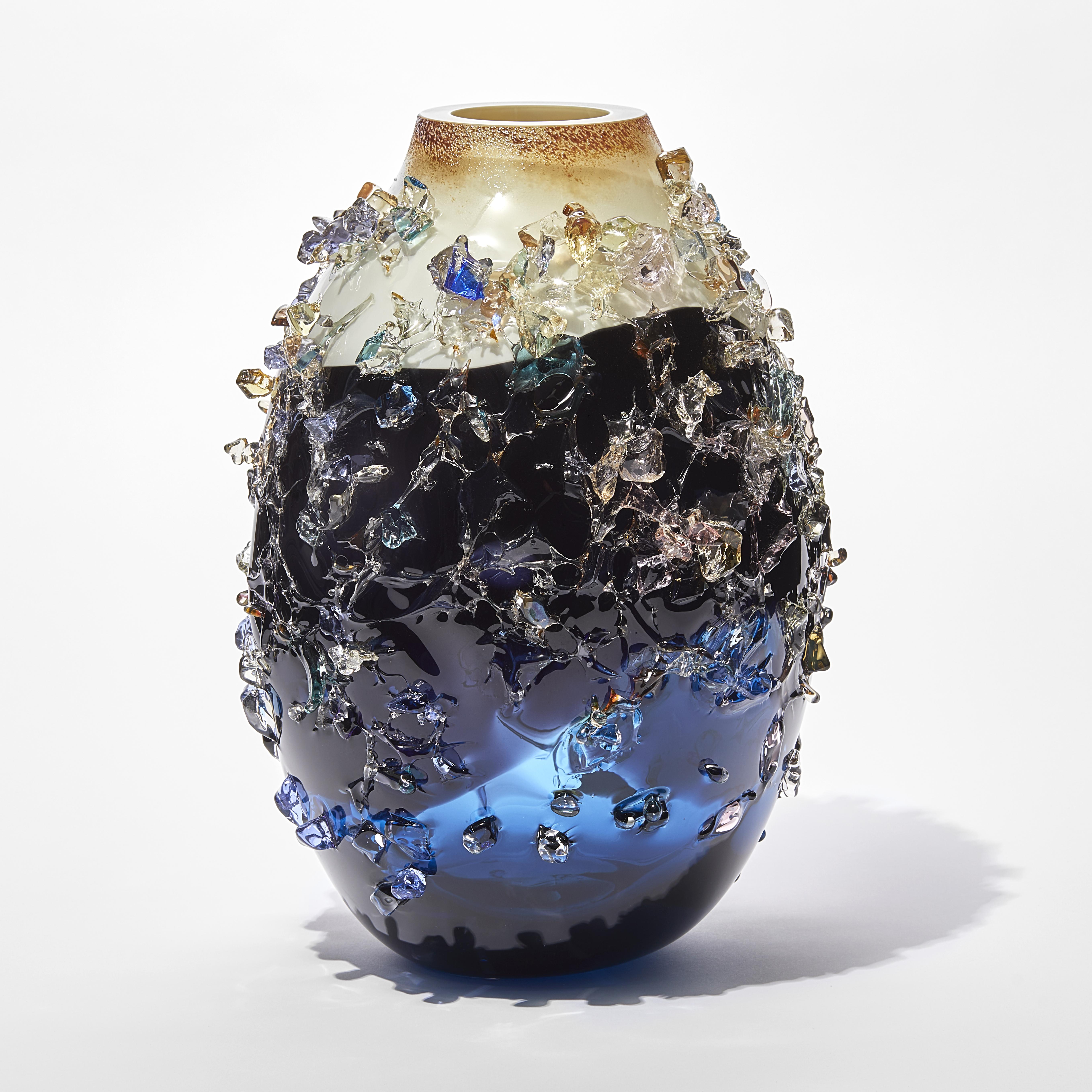 midnight blue body with soft milky cappuccino opaque top sculptural vase with multicoloured shards on the surface handmade from glass
