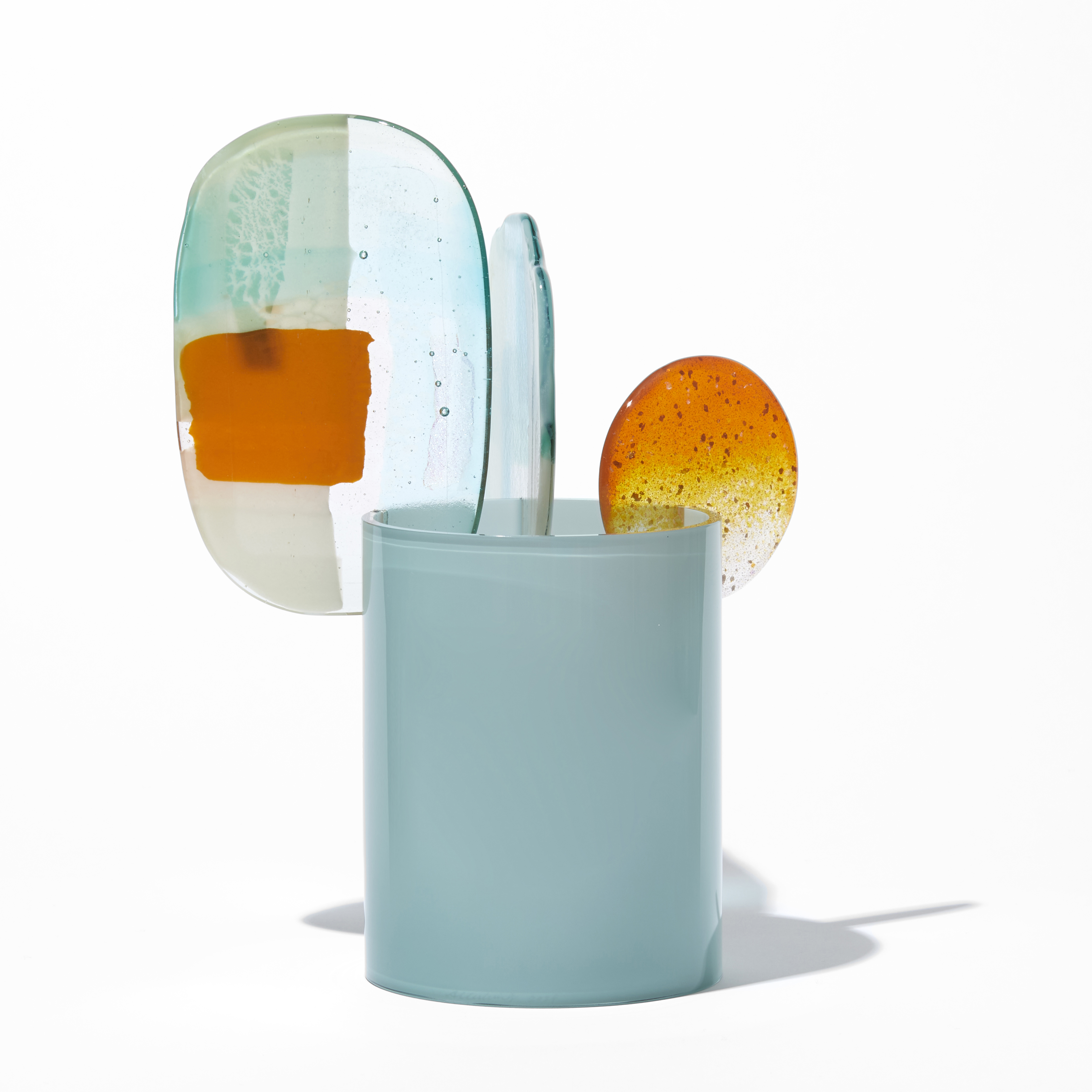 short opaque celadon cylinder with three rounded abstract finials in a mix of orange aquamarine jade turquoise white and clear hand made from blown and fused glass