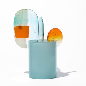 short opaque celadon cylinder with three rounded abstract finials in a mix of orange aquamarine jade turquoise white and clear hand made from blown and fused glass