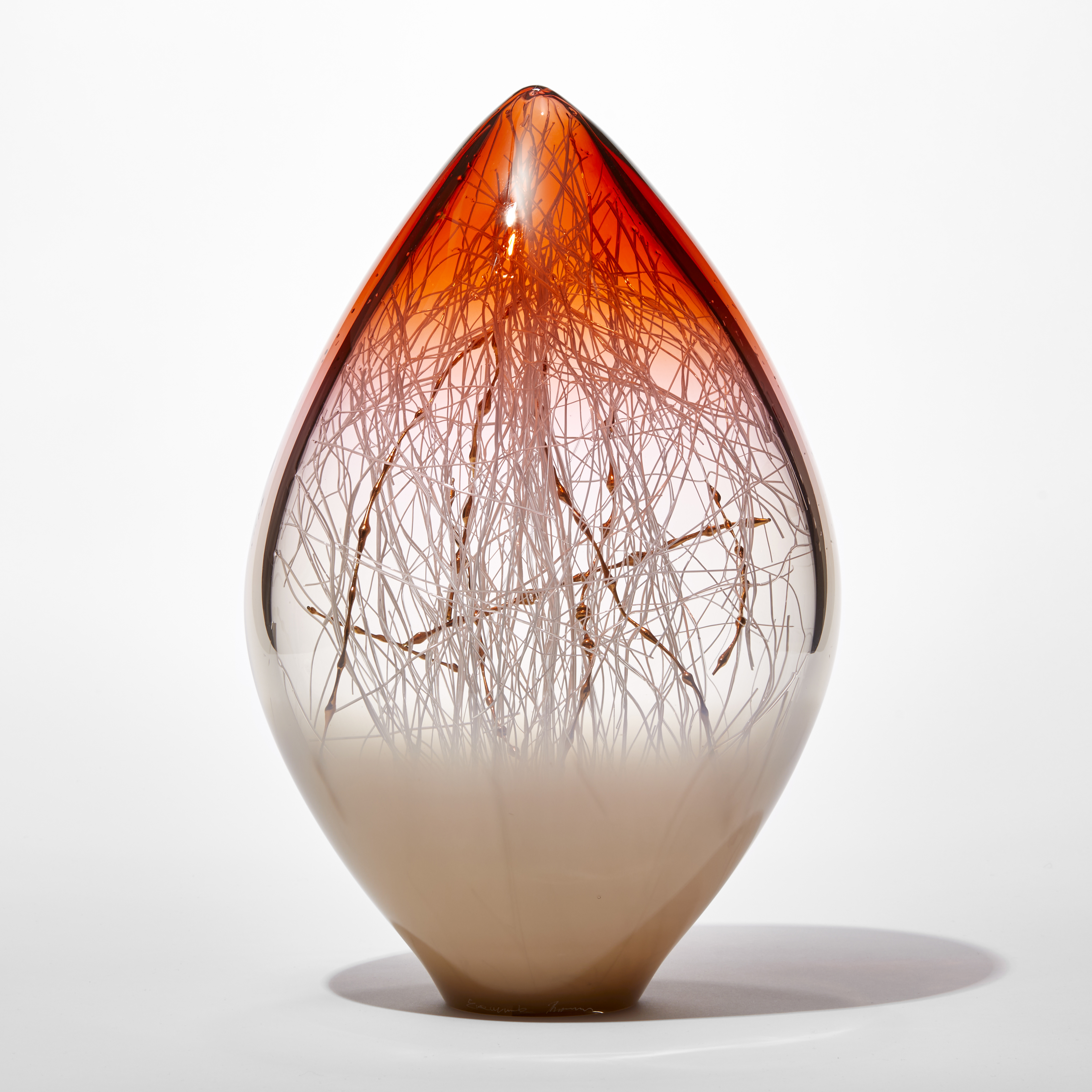 opaque and transparent pointed ovoid standing glass sculpture with soft bronze base and rich orange red top with fine white canes trapped inside intermingled with gold ones with bulbous sections