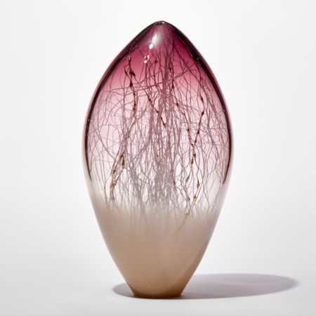 clear and opaque tall rounded glass sculpture with soft pointed top with beige base and aubergine purple top with fine white canes traversing and trapped inside mixed with gold ones with bulbous sections like seaweed
