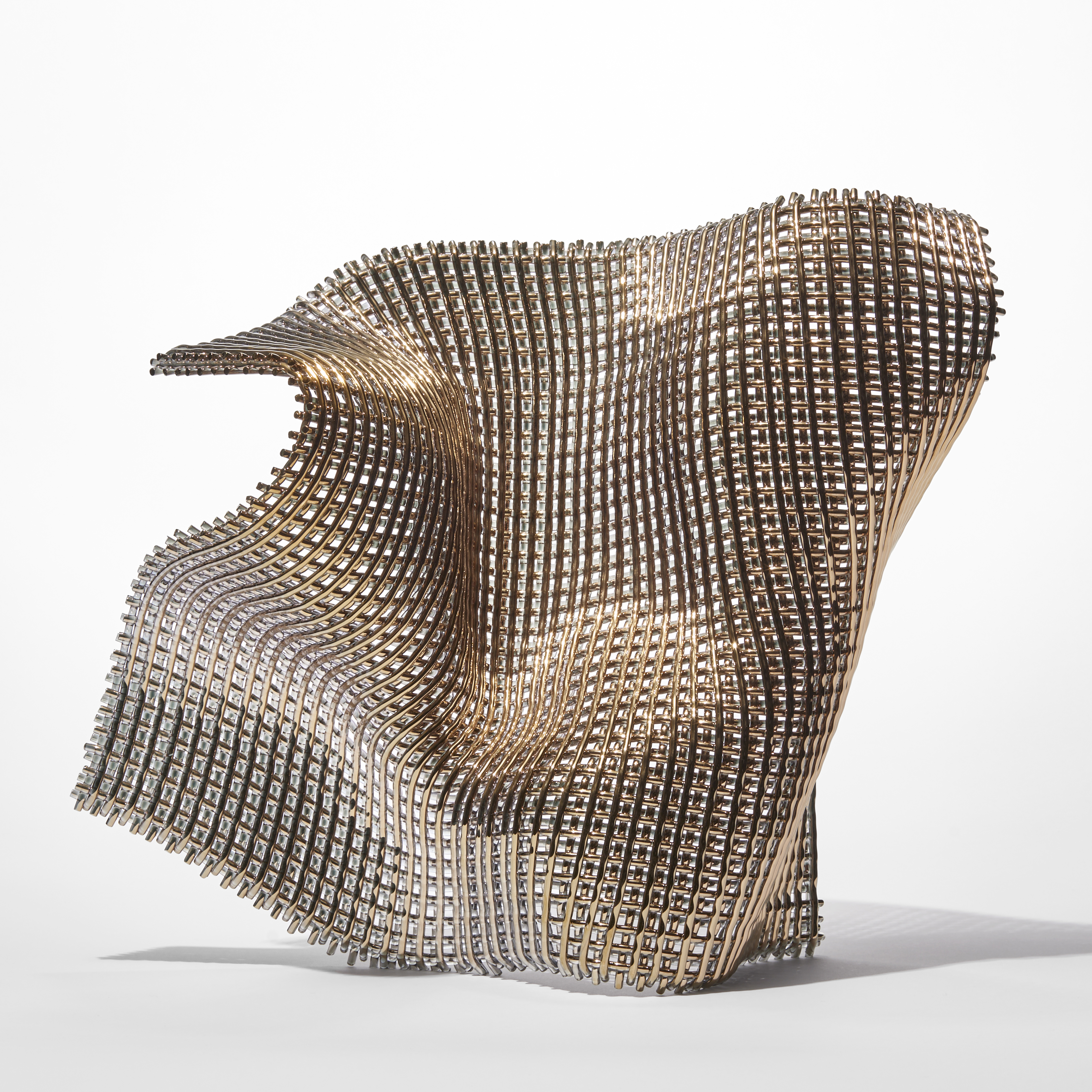 standing undulating glass sculpture with the appearance of open woven cloth with one side covered in gold hand made from fused find glass canes