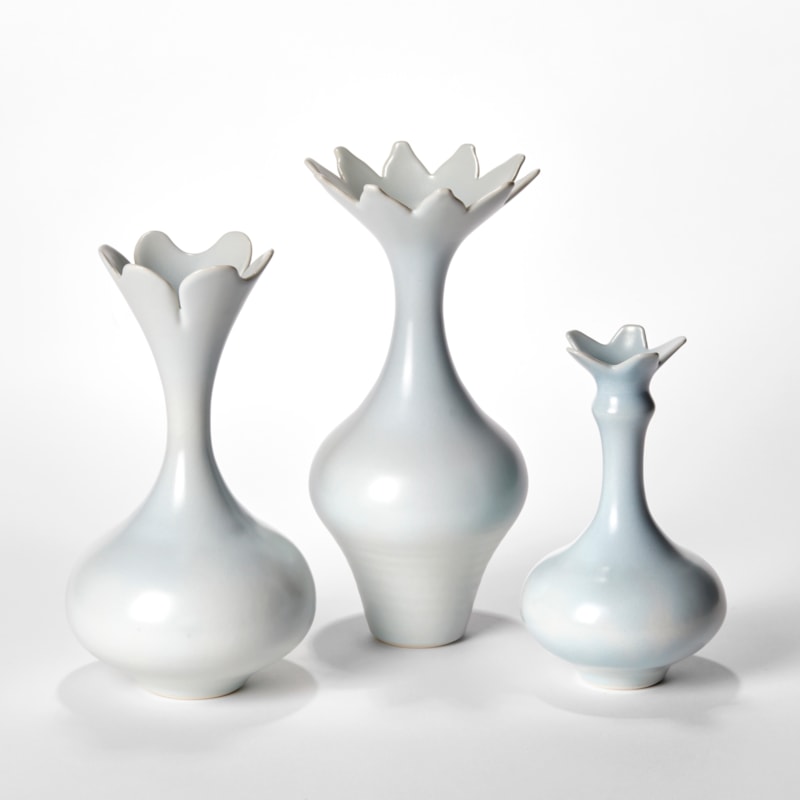 trio of turquoise elegant porcelain vases with long elegant necks rounded bases and star floral widening rims