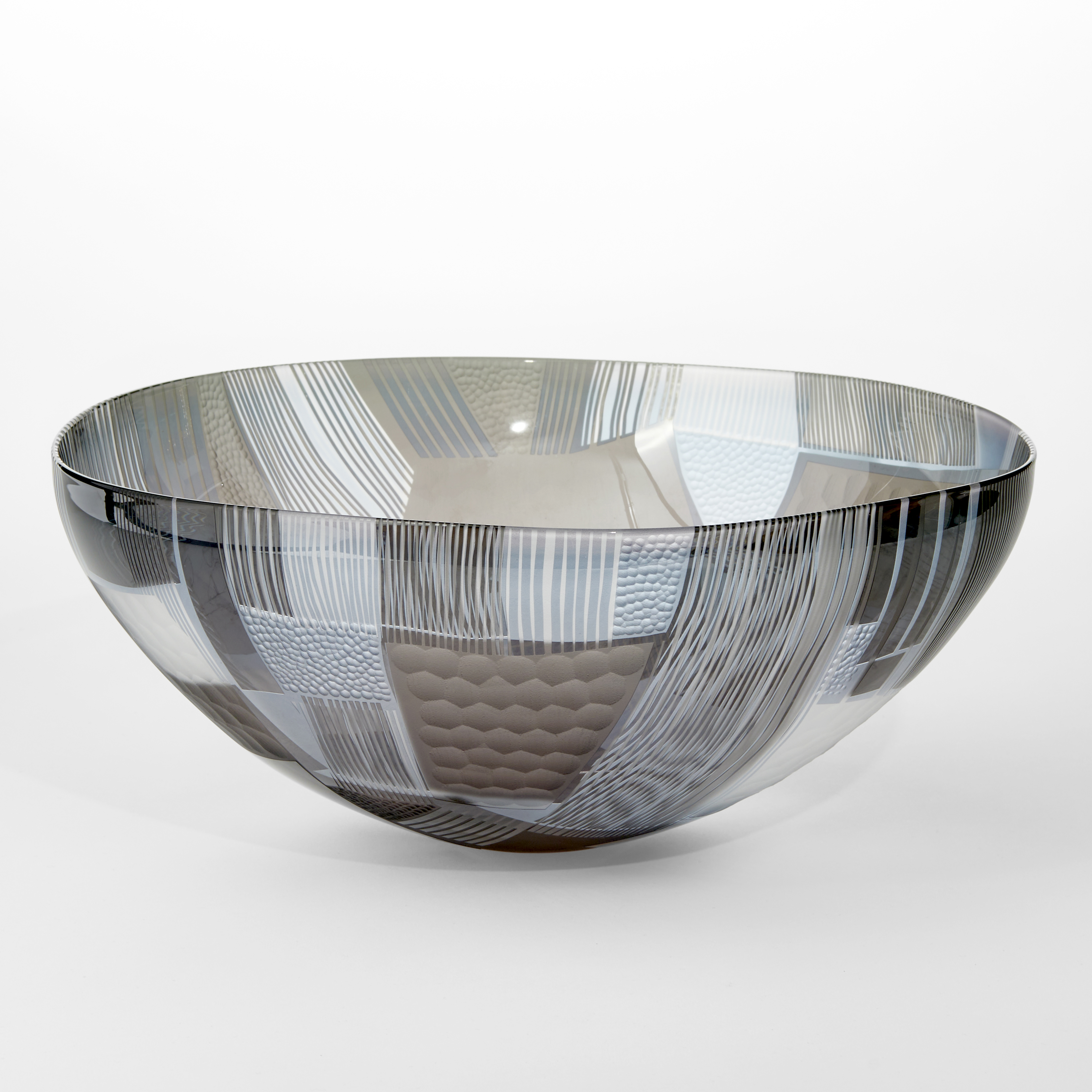 grey clear and aqua wide open bowl with cut abstract landscape patterns on both the interior and exterior surfaces hand made from glass