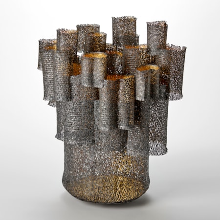 large organically perforated tubular form with a multitude of smaller tubes stacked on top of and slotted into it and on each other with a dark matt brown exterior and gold interior hand made from steel and twenty four carat gold leaf