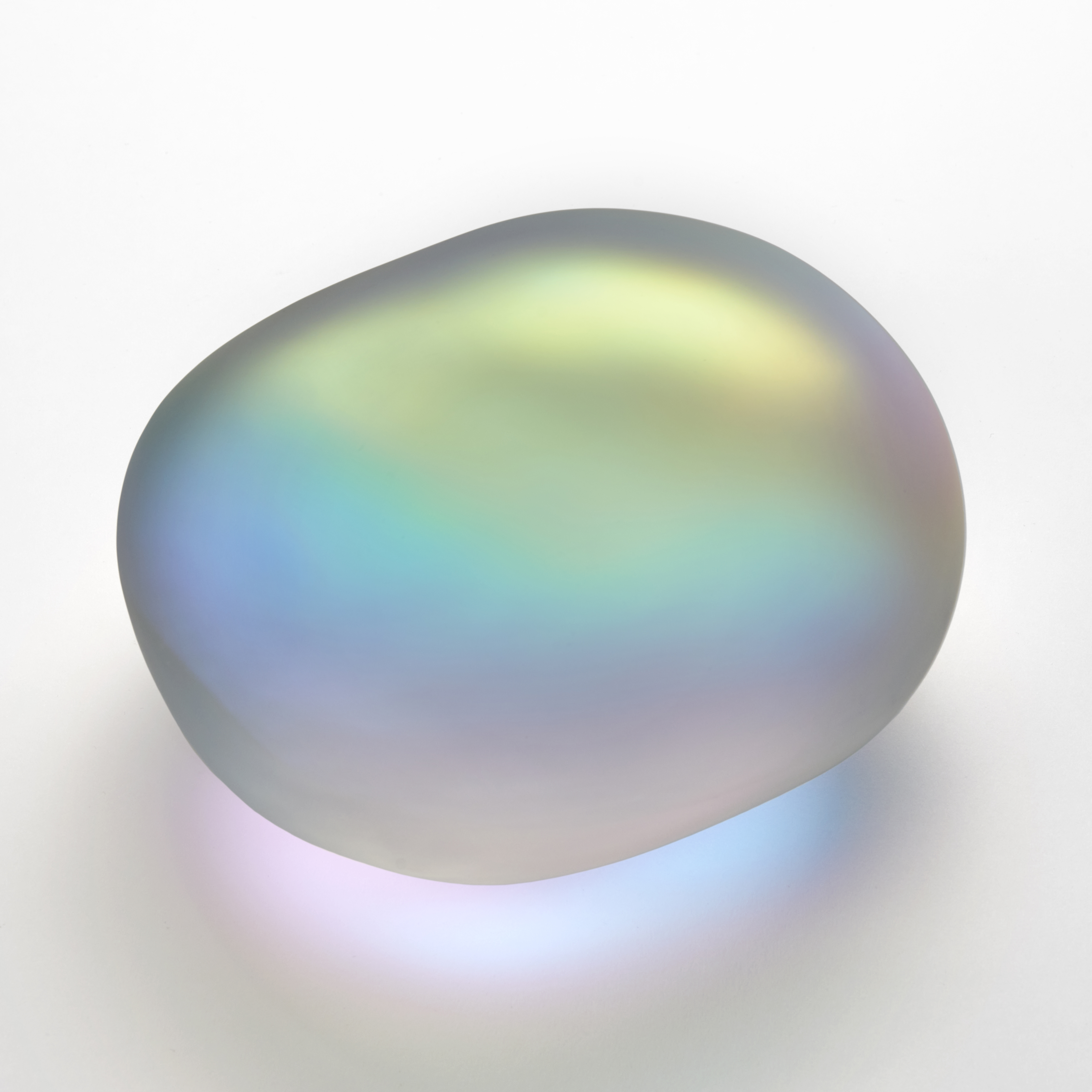 amorphic smooth opaque clear glass stone with satin surface and interior filled with a myriad of colours which appear to emanate from its interior