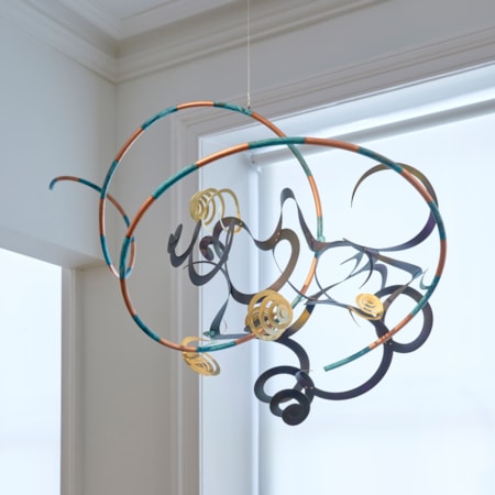 hanging kite inspired sculpture consisting of striped ribbons and curls made from hand painted copper oxydyed aluminium & brass in dark midnight indigo blue orange silver and aqua with verdigris