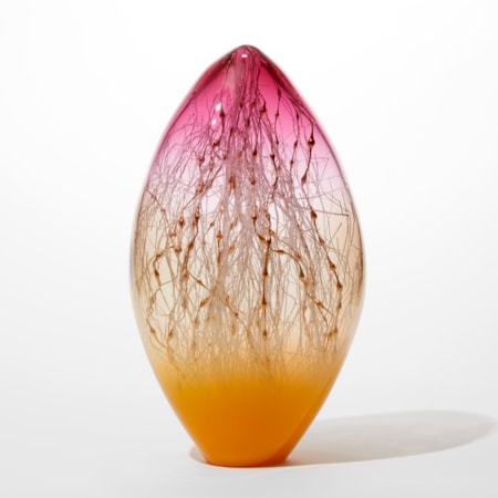 oval transparent glass sculpture with pointed top with opaque bright orange base clear middle and vibrant pink top with white and gold canes inside traversing the hollow space
