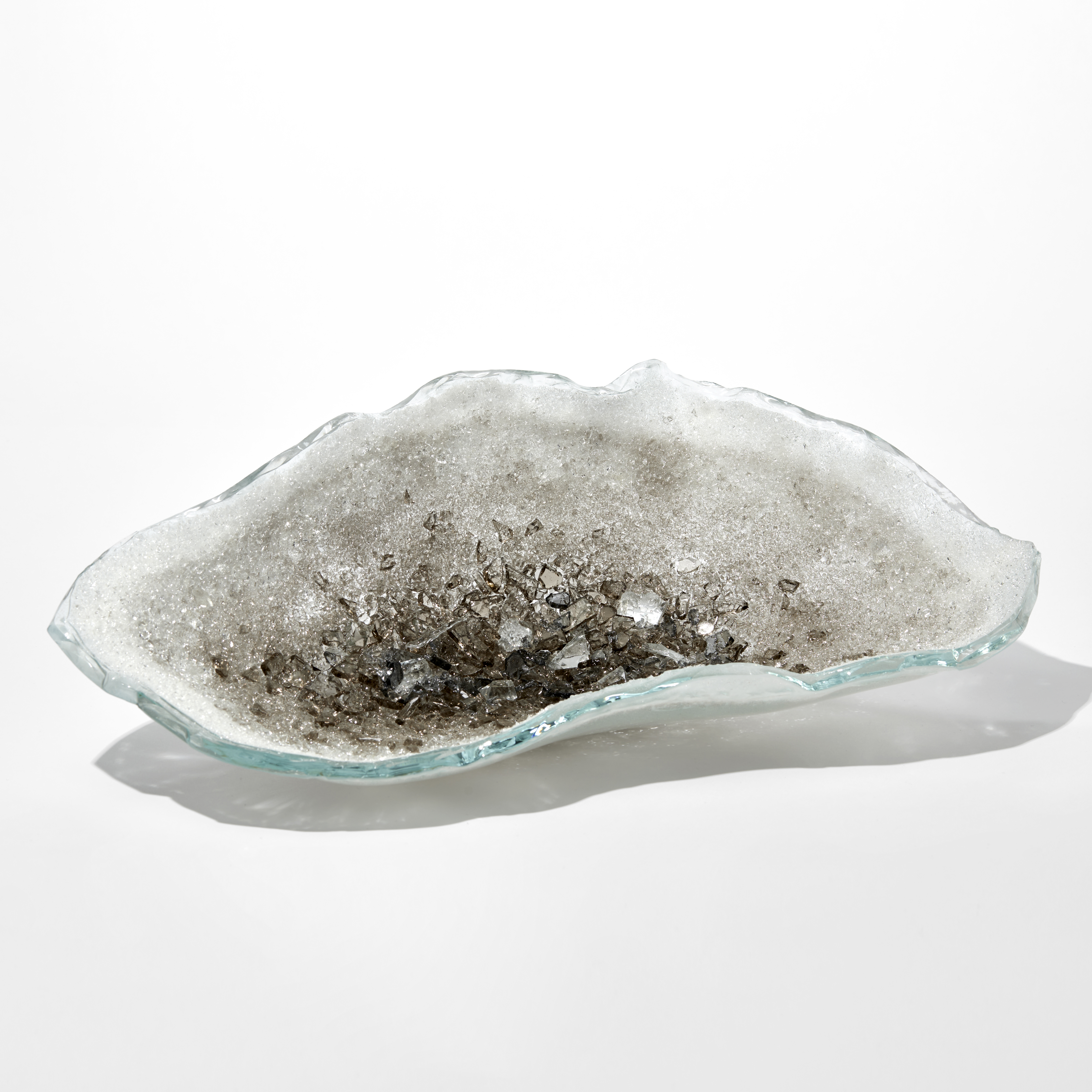 oyster shell shaped long artwork in white with soft green colouring to the edges with the interior filled with bronze coloured crystals increasing in size to the centre hand made from glass