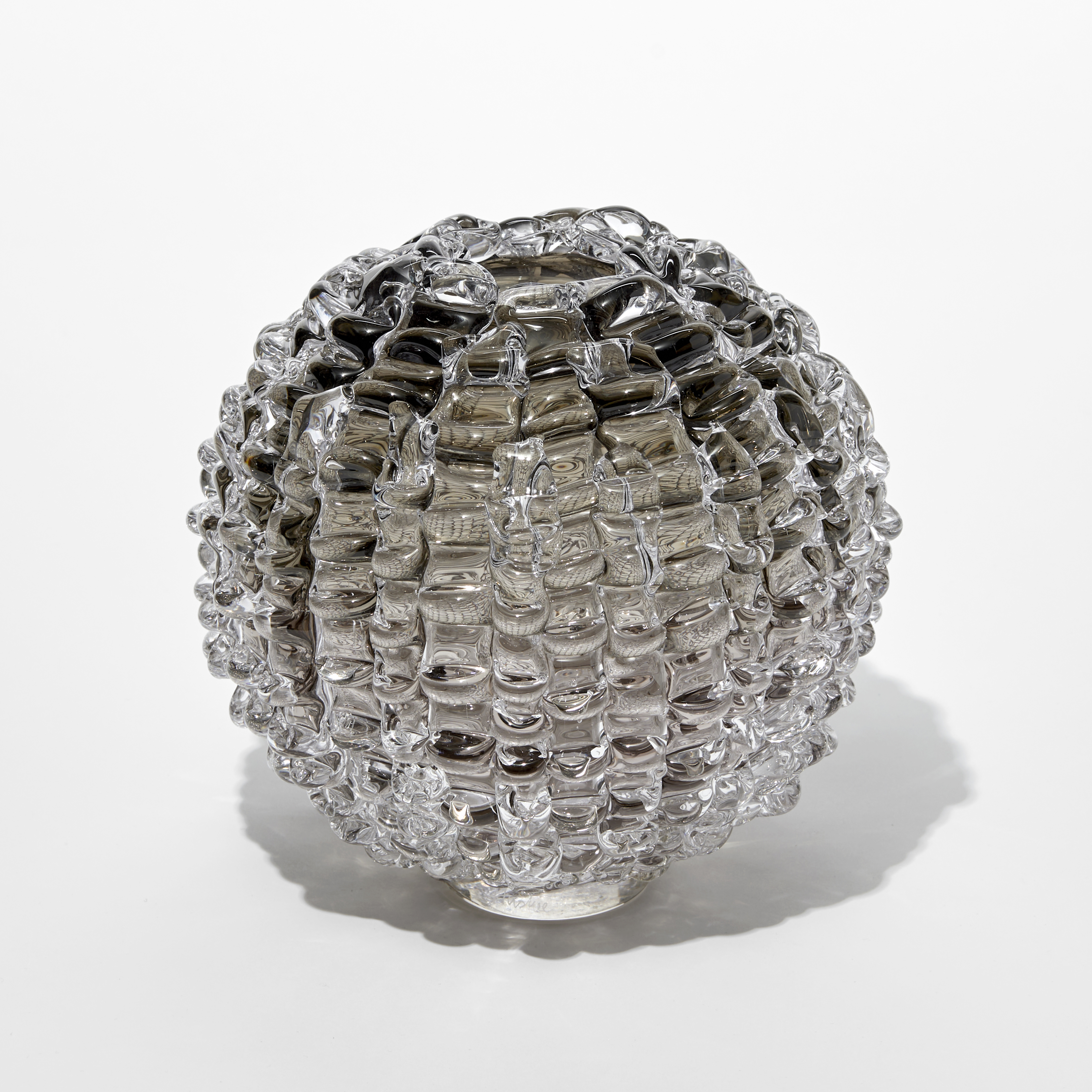 round transparent grey bronze vase with undulating ridged exterior and small top opening hand blown from glass
