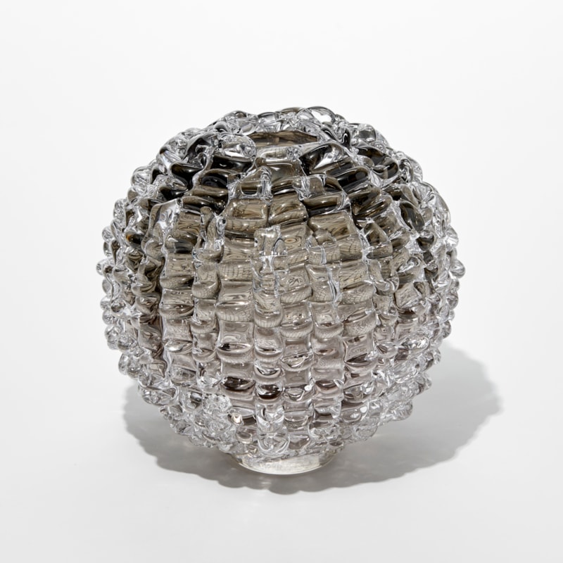 round transparent grey bronze vase with undulating ridged exterior and small top opening hand blown from glass