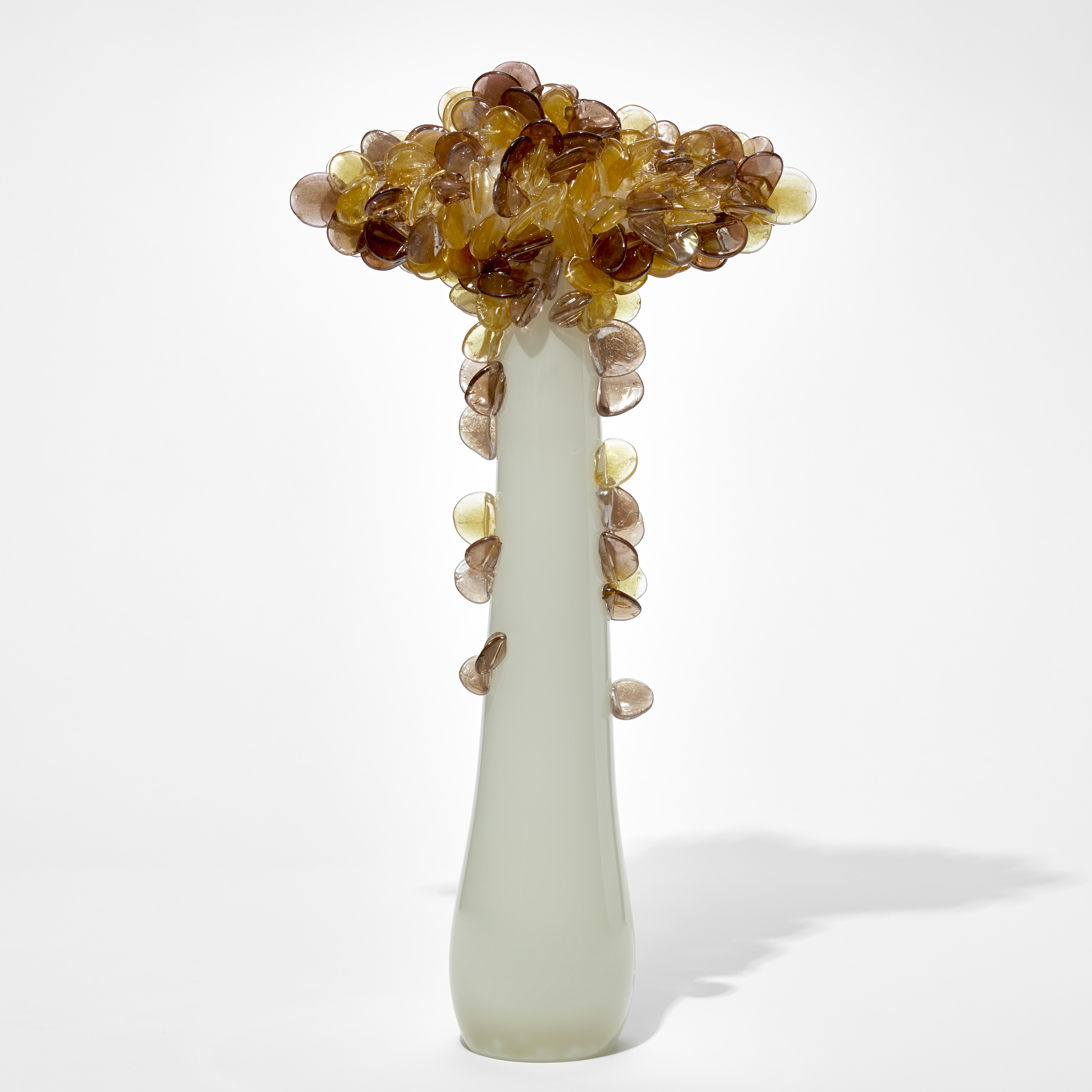 tall abstract and simplified tree sculpture with alabaster bronze coloured opaque slender trunk with a top canopy of lollipop shaped leaves in bronze brown and amber hand made from glass