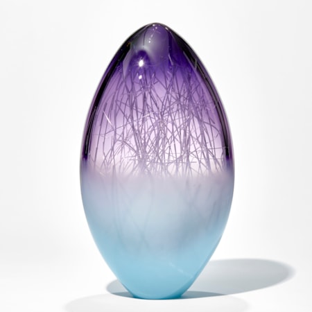 oblong shaped glass sculpture in pale turquoise and indigo with internal wire structure resembling tree branches