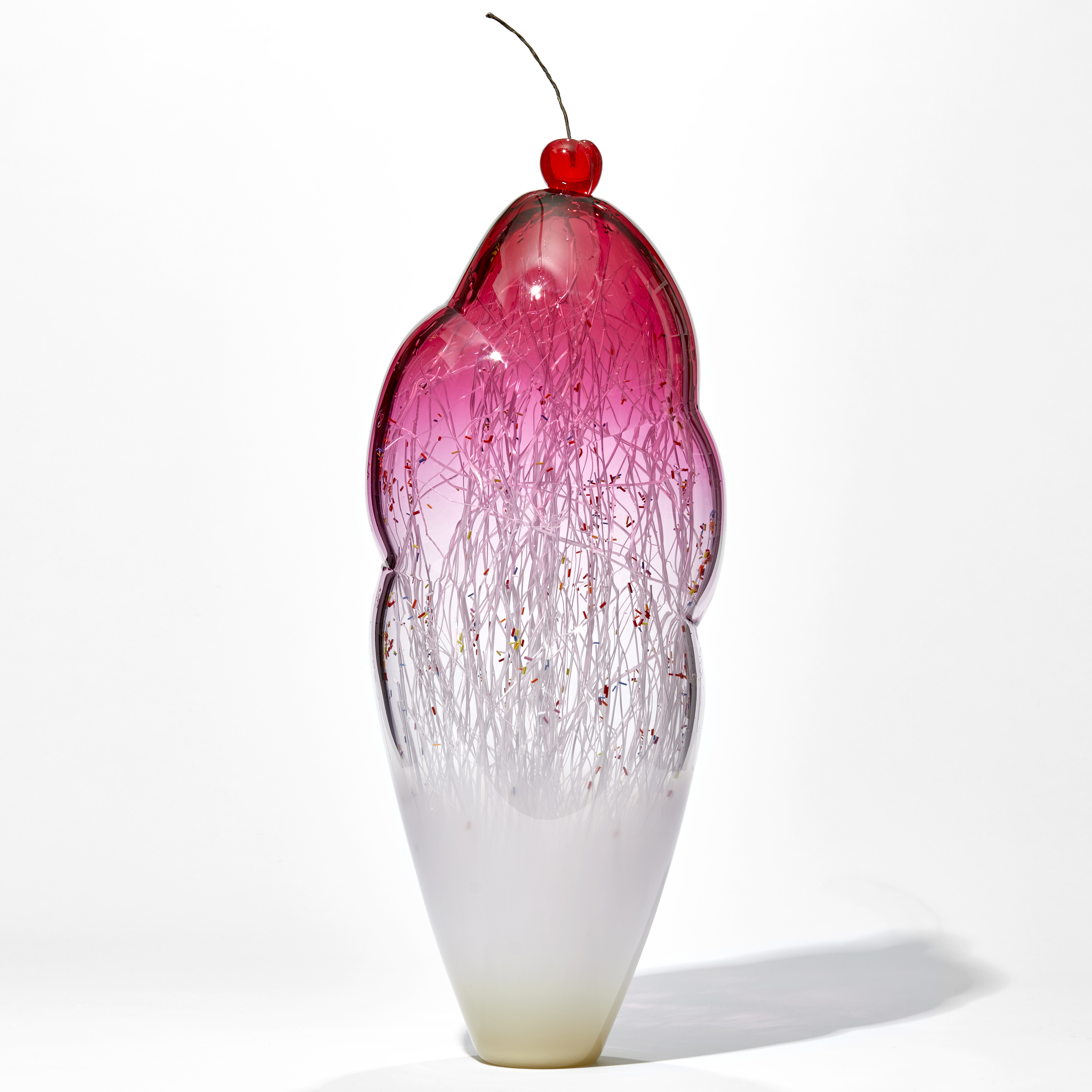 tall and thin decorative glass ornament in white and pink with natural looking internal structure and cherry on top