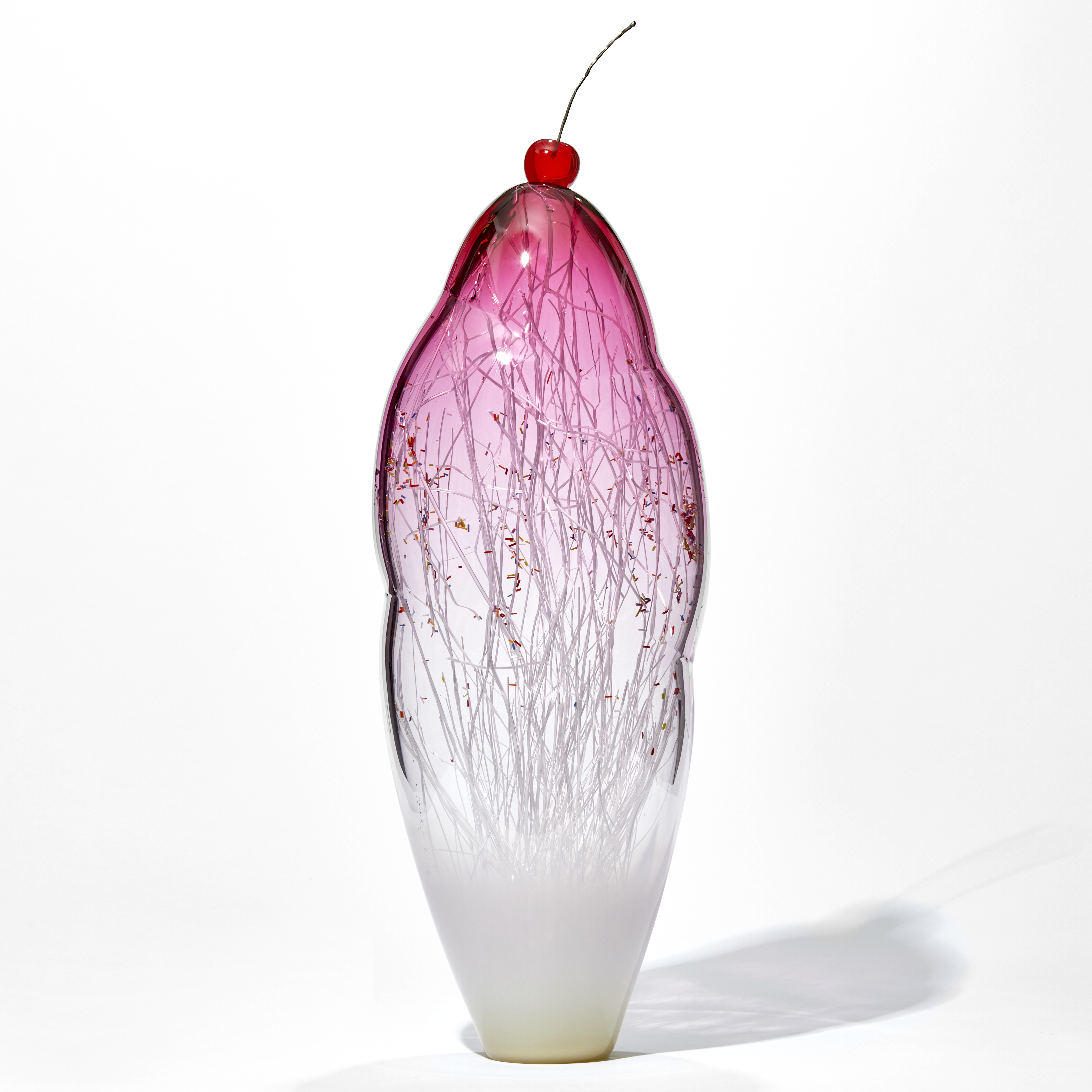 tall and thin decorative glass ornament in white and pink with natural looking internal structure and cherry on top