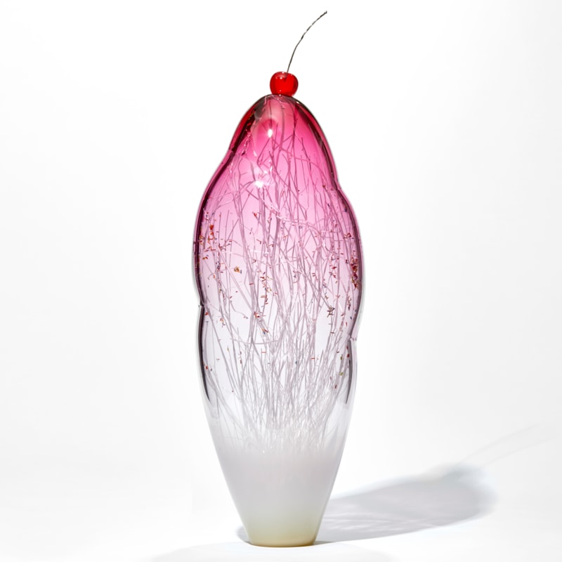 tall and thin decorative glass ornament in white and pink with natural looking internal structure and cherry on top
