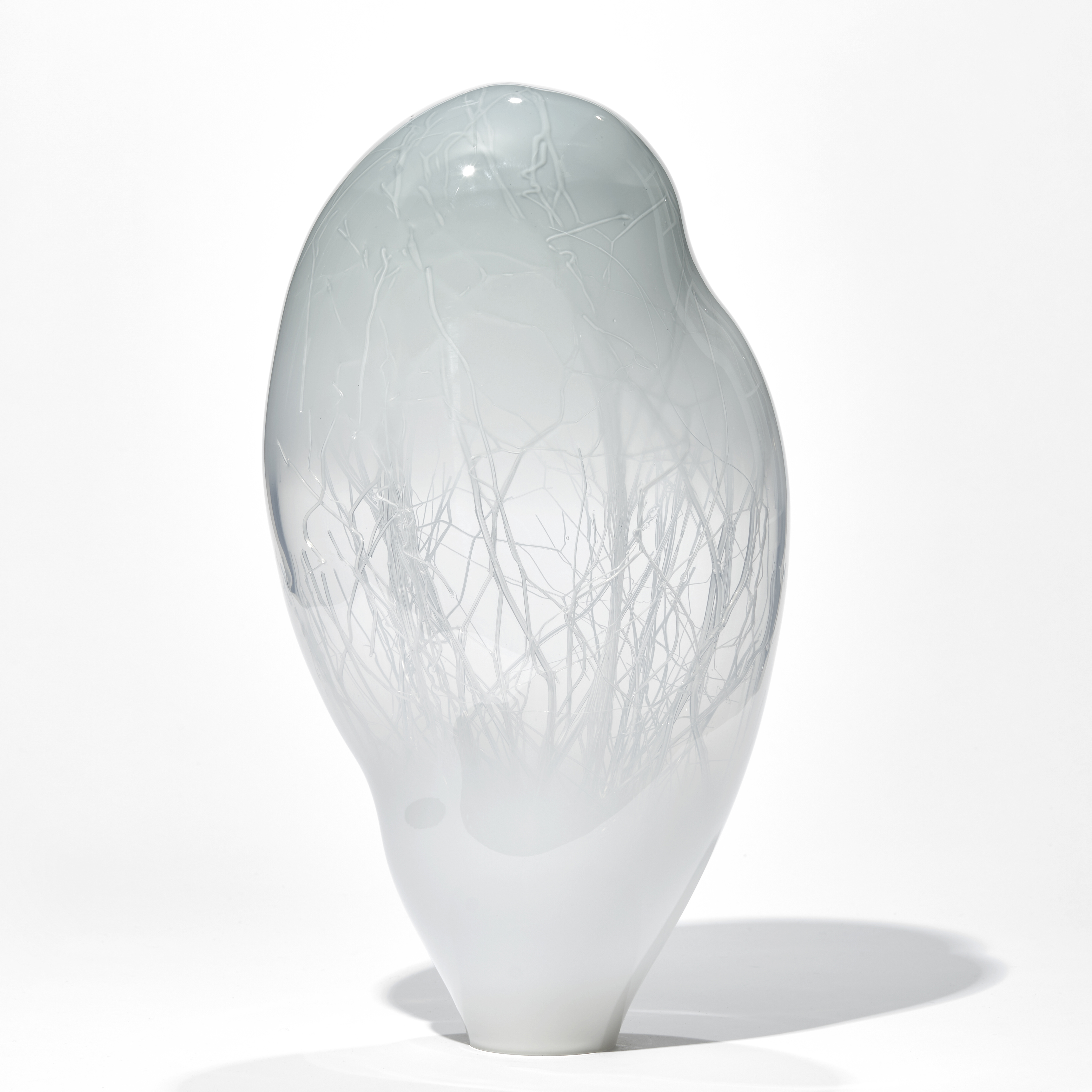 grey floating orb shaped art glass sculpture with internal tree branch structure