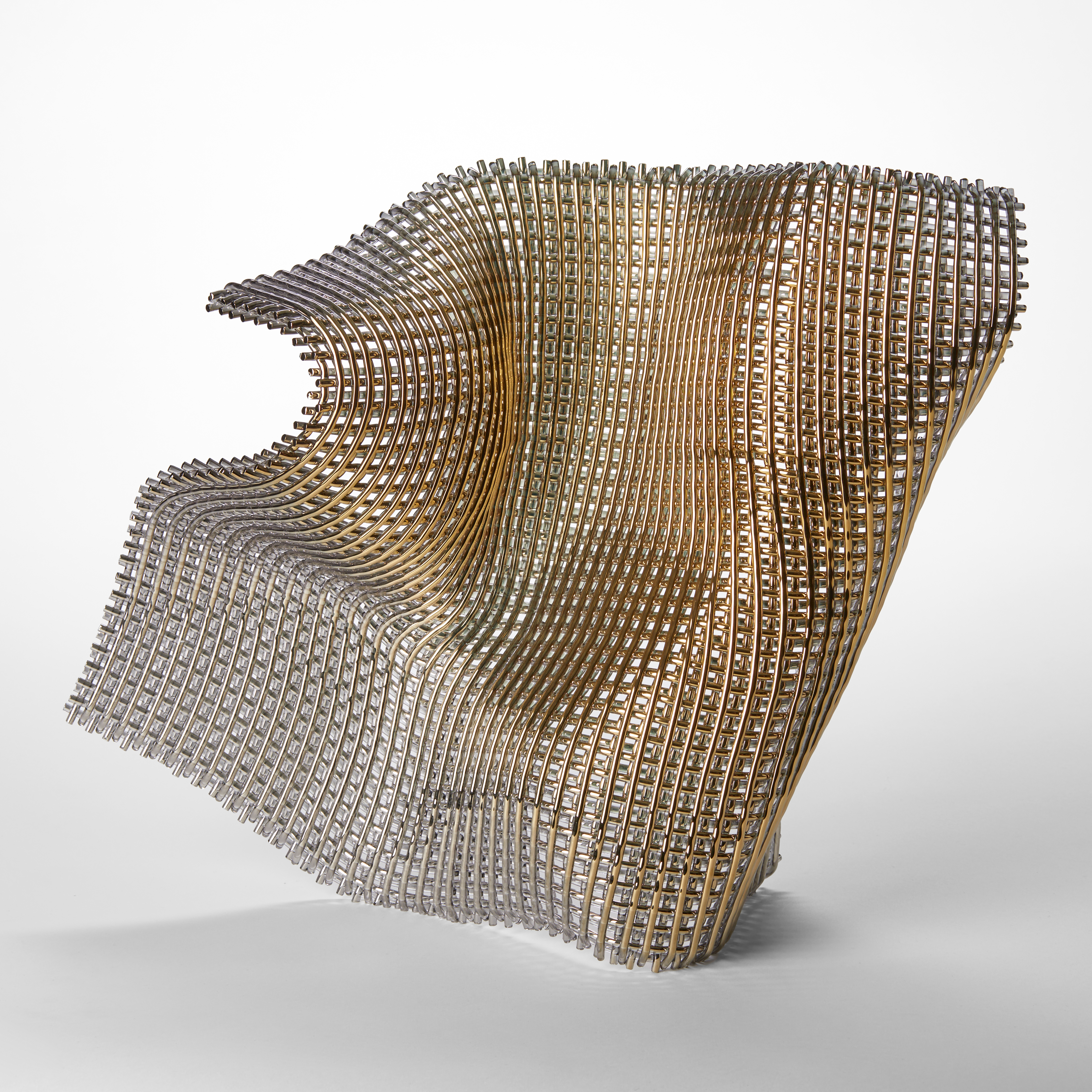 standing shimmering fluttering woven piece of fabric with large open weave and golden surface hand made from glass and twenty four carat gold 