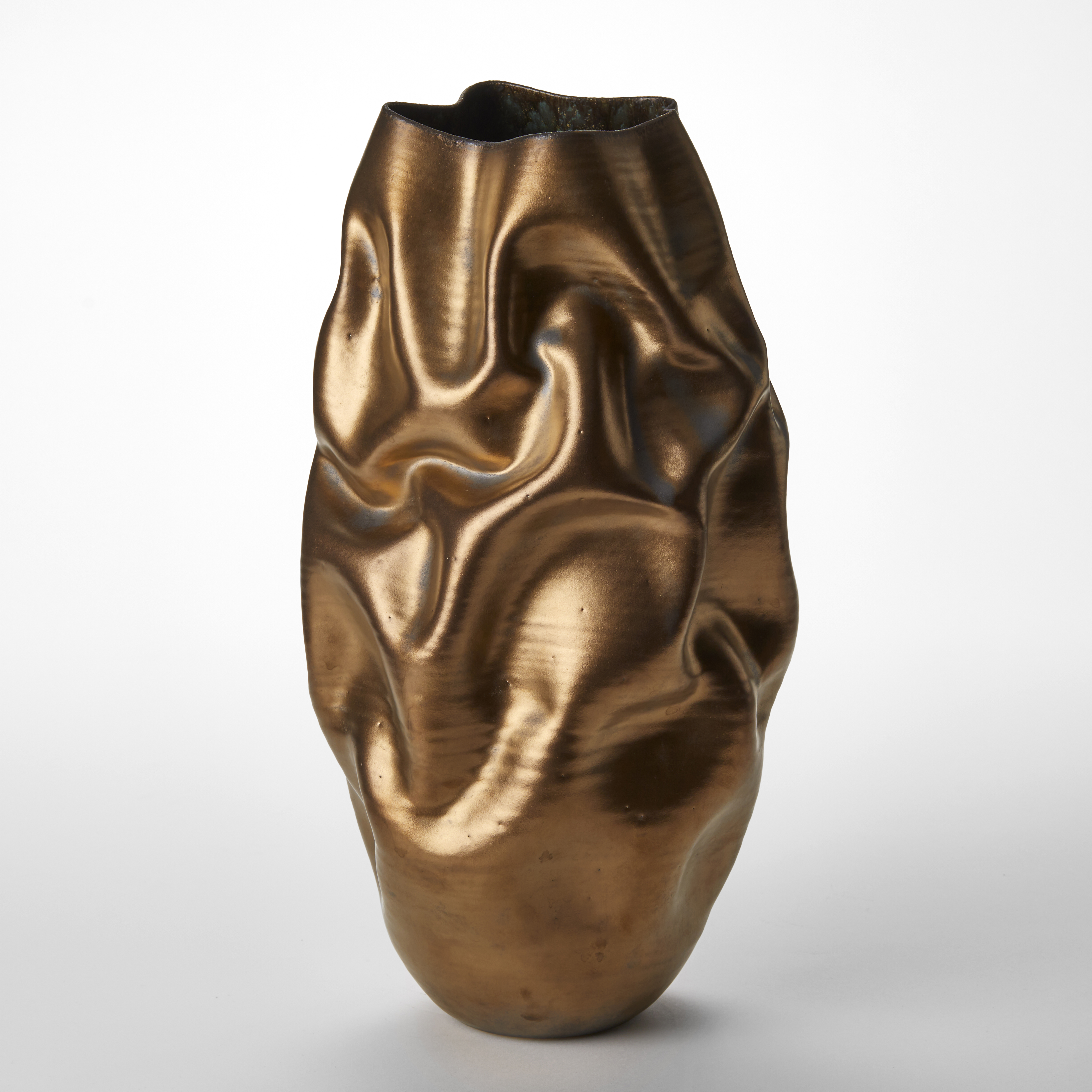 tall wrinkled and creased long oval shaped vase with organically undulating surface and burnished gold finish hand made from clay