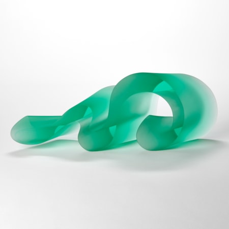 curling undulating bright jade lime green opaque sculpture with two flat sides and two curling sides following the movement of the piece as it waves and snakes along in form hand made from cast glass